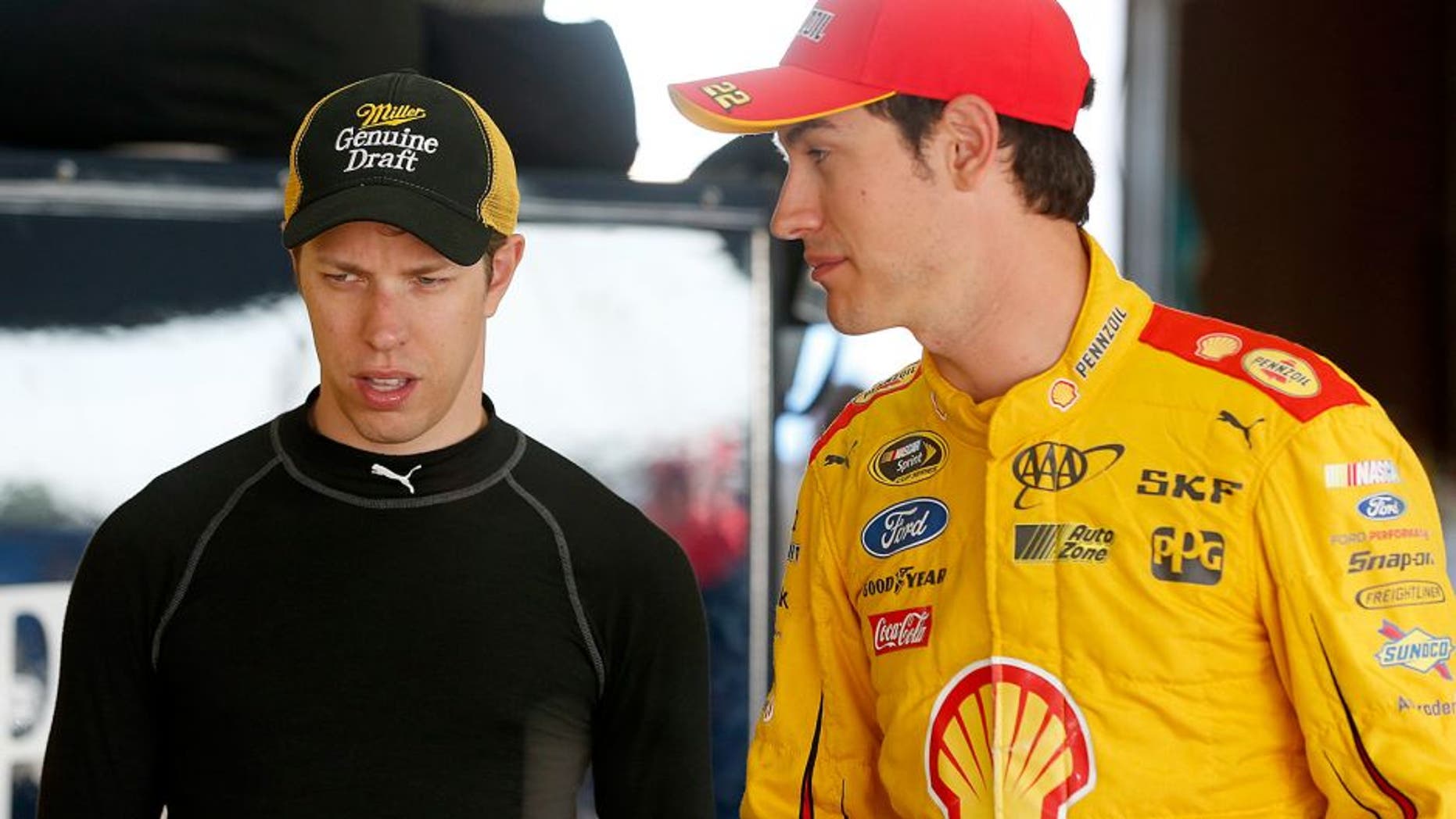 BROOKLYN, MI - AUGUST 15: (R-L) Joey Logano, driver of the #22 Shell Pennzoil Ford, and Brad Keselowski, driver of the #2 Miller Lite Ford, talk in the garage during practice for the NASCAR Sprint Cup Series Pure Michigan 400 at Michigan International Speedway on August 15, 2015 in Brooklyn, Michigan. (Photo by Brian Lawdermilk/NASCAR via Getty Images)