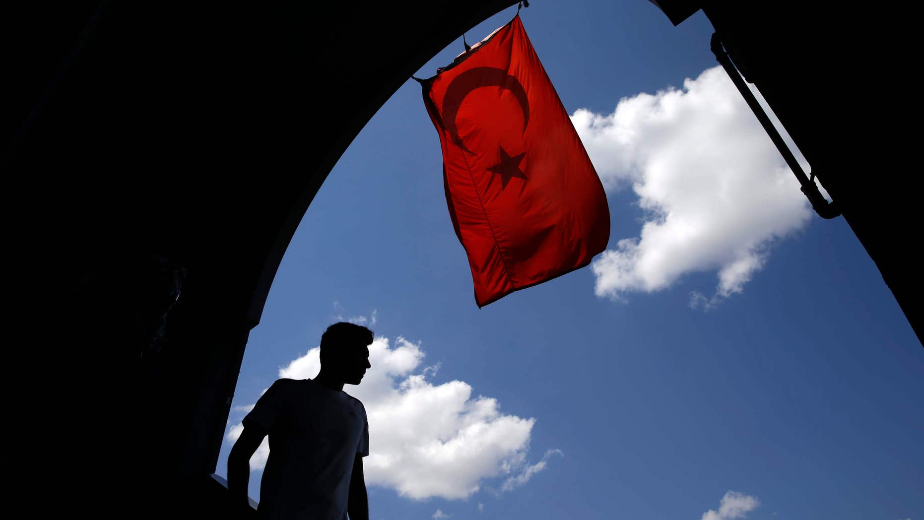 Aug. 14, 2016: A pedestrian passes under a Turkish flag in Istanbul.