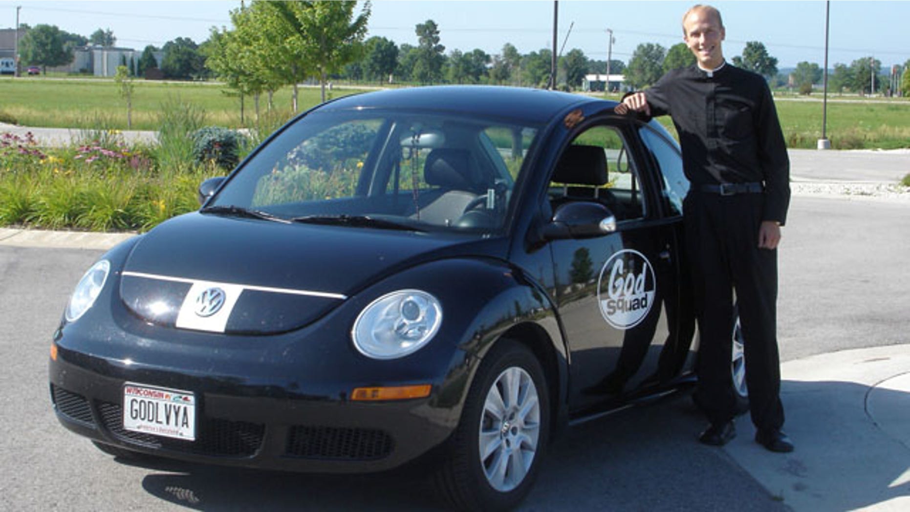 Rev. Luke Strand, pastor of Holy Family Catholic Church in Fond du Lac, Wis., stands with his "God Squad" vehicle in this undated photo.
