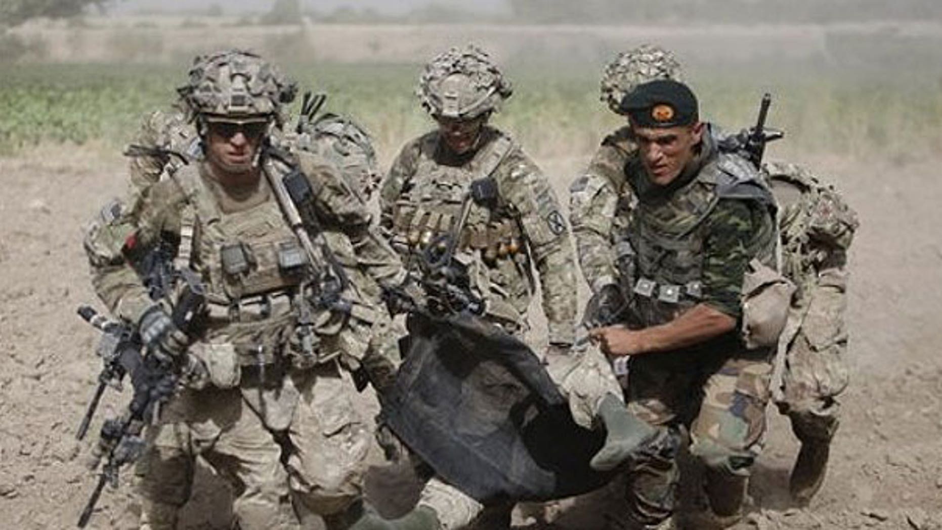 July 30: An Afghan National Army soldier along with U.S soldiers carry a wounded U.S soldier following an attack to a medevac helicopter.