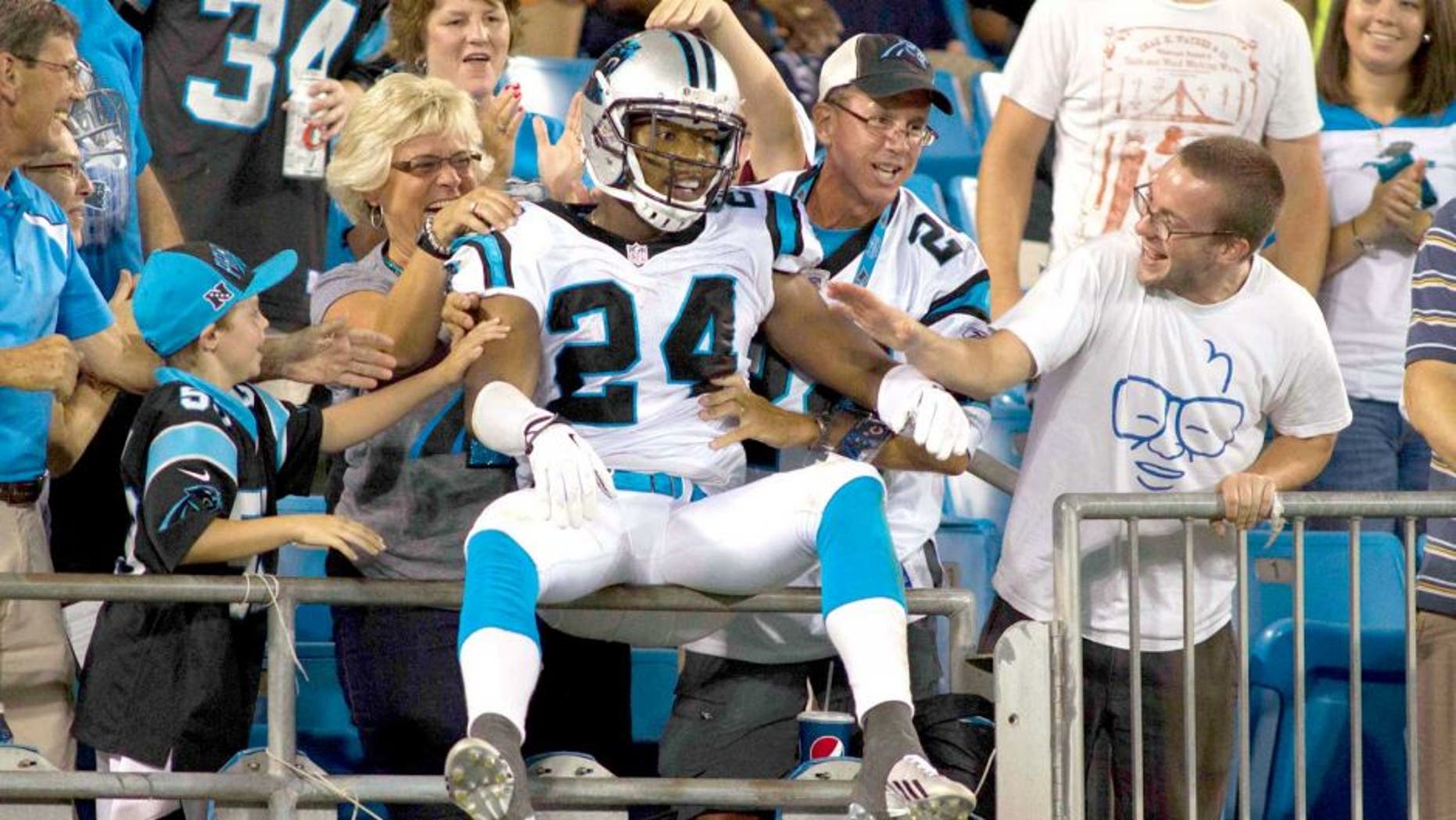 Aug 9, 2013; Charlotte, NC, USA; Carolina Panthers cornerback Josh Norman (24) jumps up in the stands to celebrate after returning an interception for a touchdown during the second half against the Chicago Bears. The Panthers defeated the Bears 24-17. Mandatory Credit: Jeremy Brevard-USA TODAY Sports