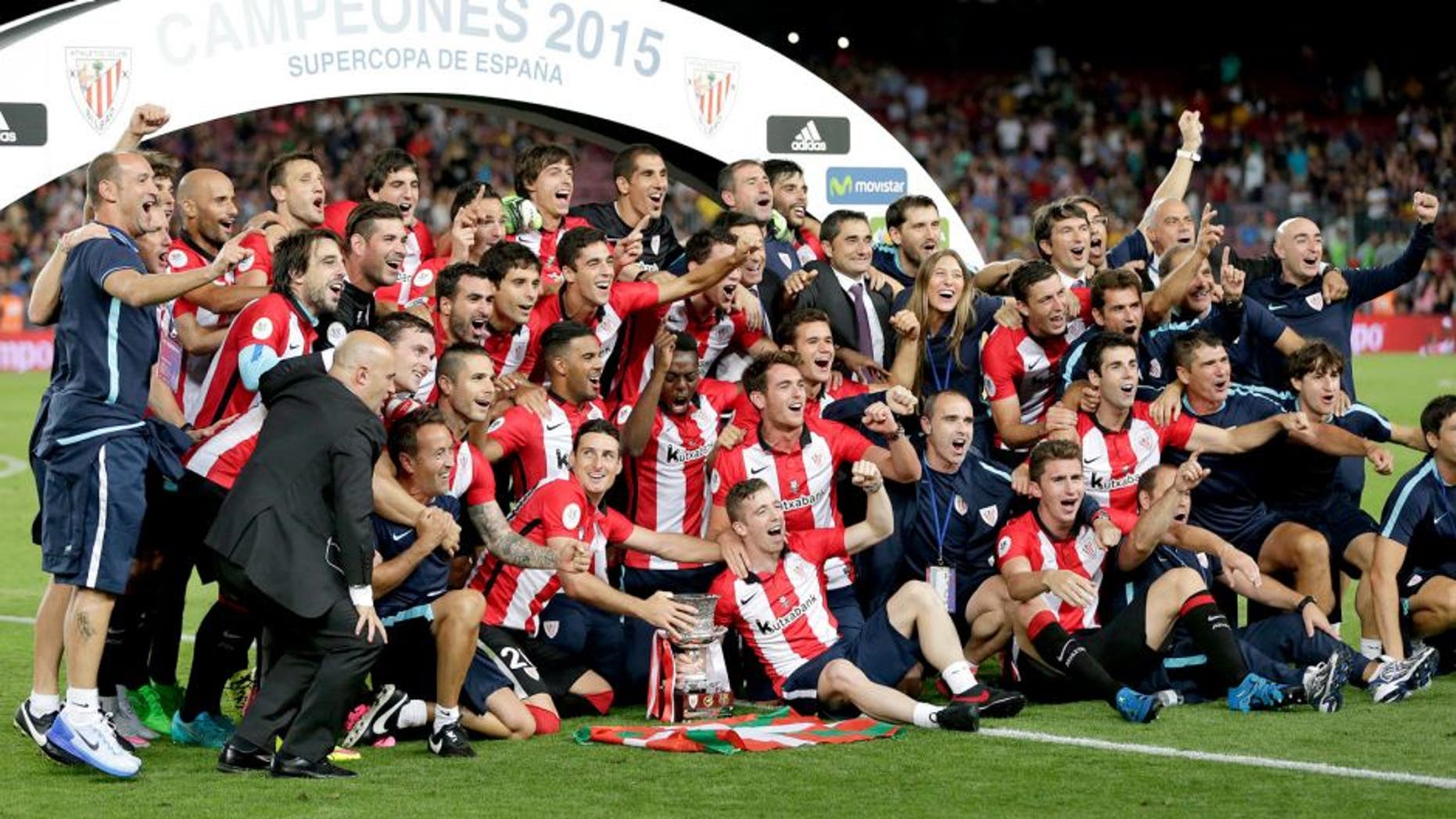 Bilbao teammates celebrate with the trophy after the second leg Spanish Super Cup soccer match between FC Barcelona and Athletic Bilbao at the Camp Nou stadium in Barcelona, Spain, Monday, Aug.17, 2015. (AP Photo/Emilio Morenatti)
