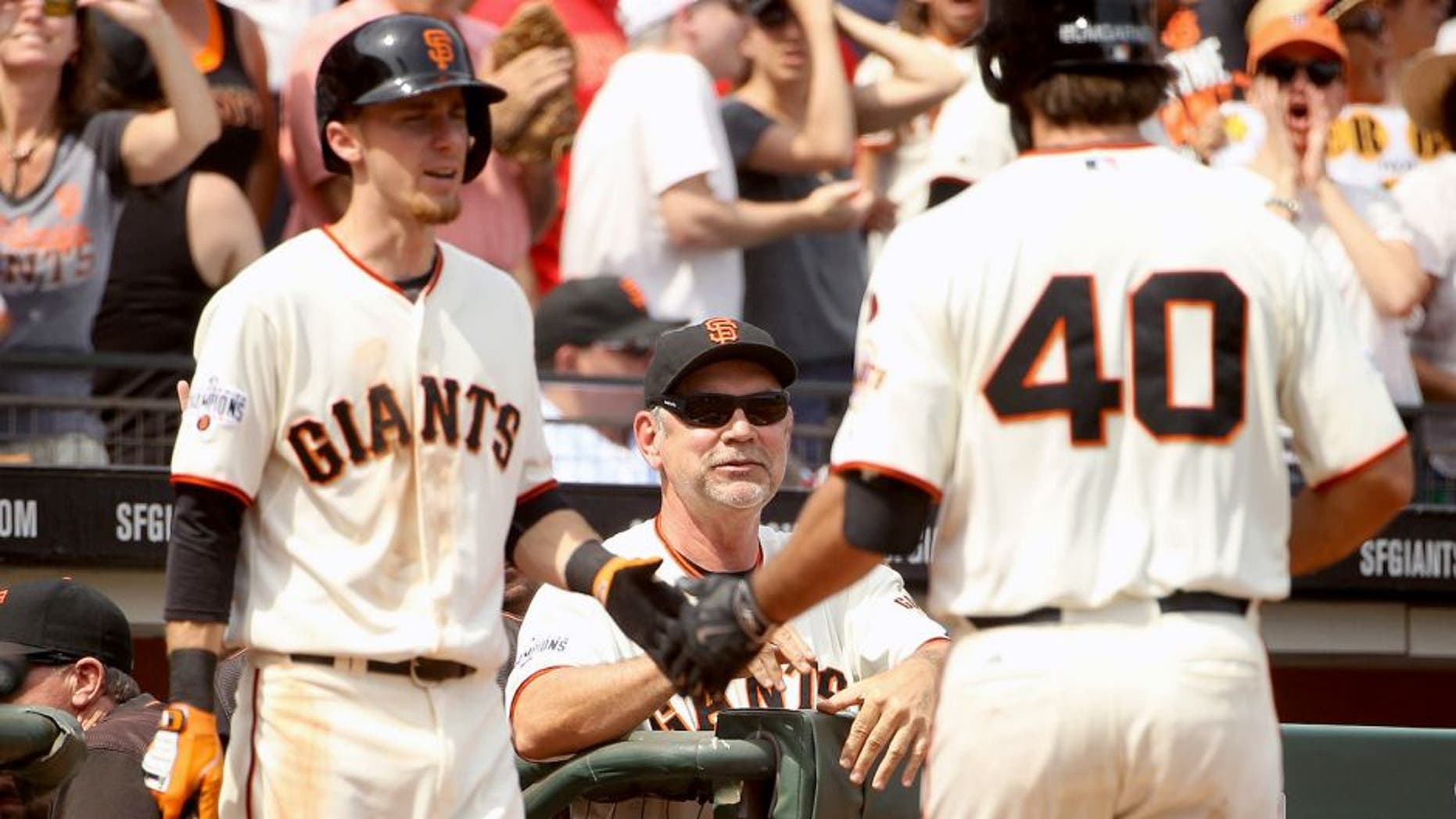 SAN FRANCISCO, CA - AUGUST 16: Manager Bruce Bochy smiles as Matt Duffy #5 congratulates Madison Bumgarner #40 of the San Francisco Giants after Bumgarner hit a home run in the seventh inning against the Washington Nationals at AT&T Park on August 16, 2015 in San Francisco, California. (Photo by Ezra Shaw/Getty Images)