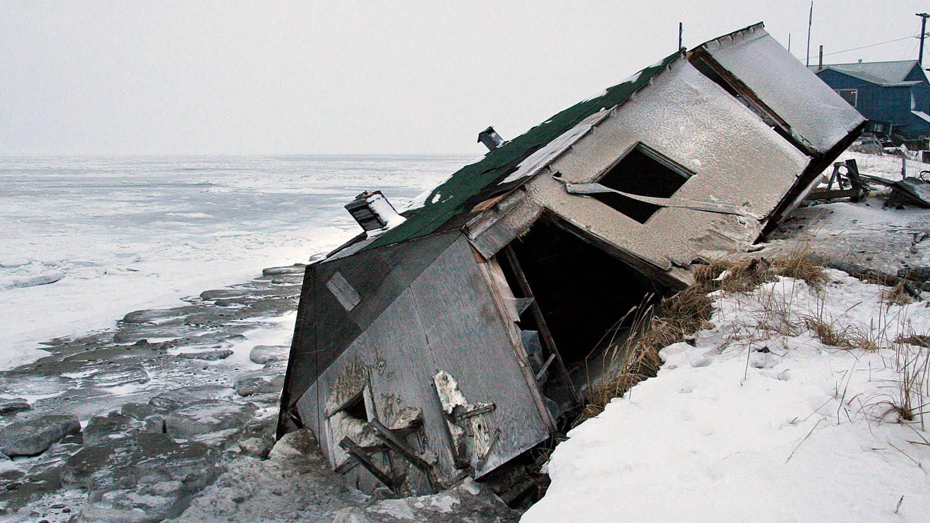 FILE - In this Dec. 8, 2006, file photo, Nathan Weyiouanna's abandoned house at the west end of Shishmaref, Alaska, sits on the beach after sliding off during a fall storm in 2005.
