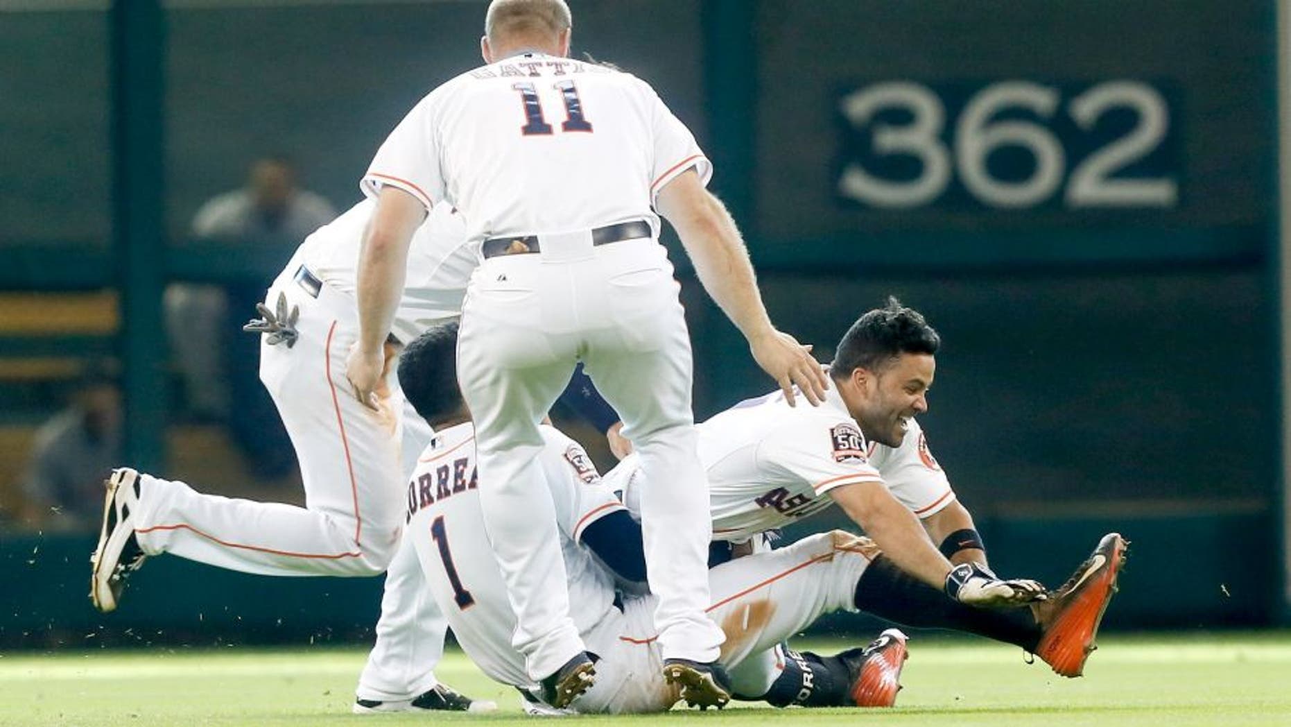 HOUSTON, TX - AUGUST 16: Jose Altuve #27 of the Houston Astros celebrates with Carlos Correa, Evan Gattis #11 and Jake Marisnick #6 after hitting walkoff single to beat the Detroit Tigers 6-5 at Minute Maid Park on August 16, 2015 in Houston, Texas. (Photo by Bob Levey/Getty Images)