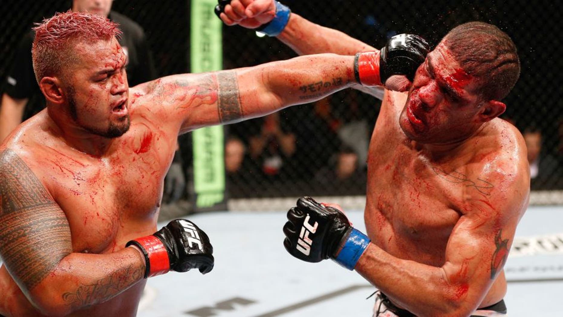 BRISBANE, AUSTRALIA - DECEMBER 07: (L-R) Mark Hunt punches Antonio "Bigfoot" Silva in their heavyweight fight during the UFC Fight Night event at the Brisbane Entertainment Centre on December 7, 2013 in Brisbane, Australia. (Photo by Josh Hedges/Zuffa LLC/Zuffa LLC via Getty Images)