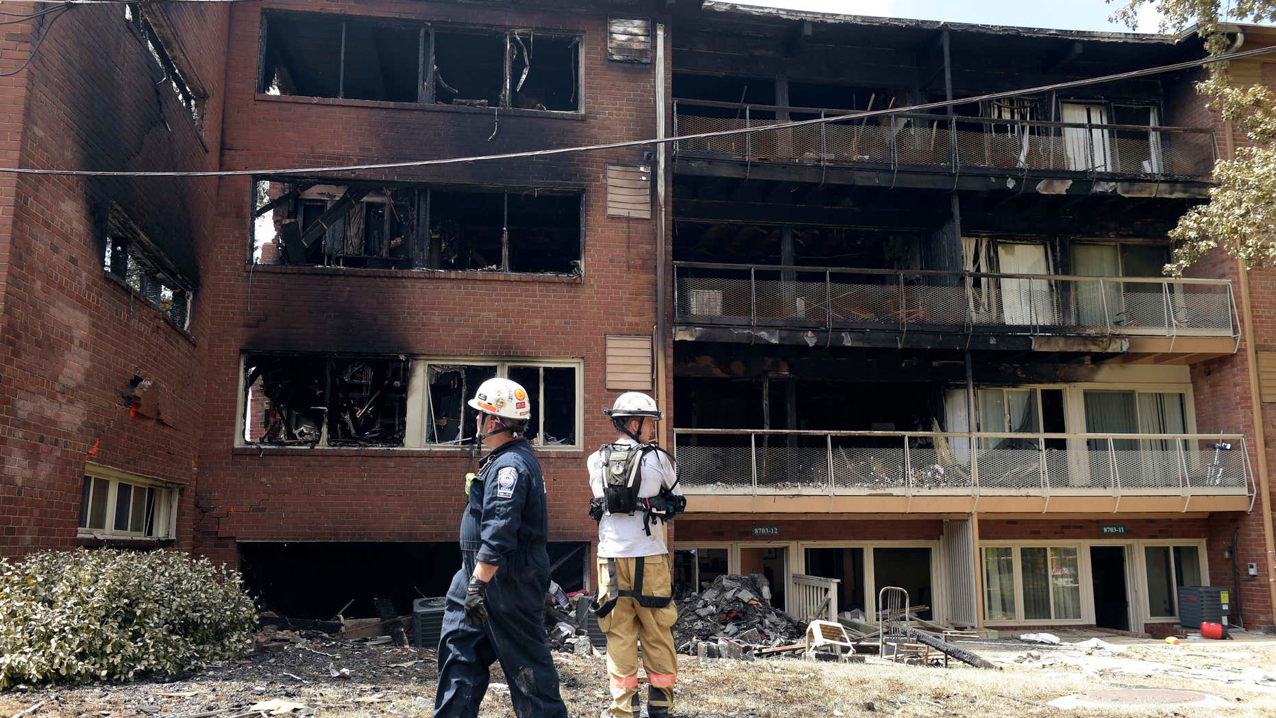 FILE - In this Thursday, Aug. 11, 2016, file photo, emergency personnel view the scene of an apartment building fire in Silver Spring, Md.