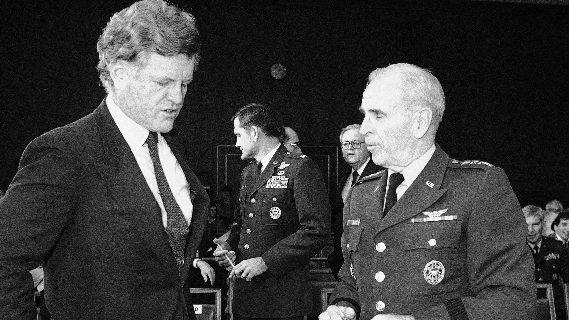 FILE - In this Feb. 1, 1983 file photo, Sen. Edward Kennedy, D-Mass, left, a member of the Senate Armed Services committee, talks with the chairman of the Joint Chiefs of Staff, Gen. John W. Vessey, on Capitol Hill, Washington, during a break in the hearing concerning the proposed 1984 federal budget.