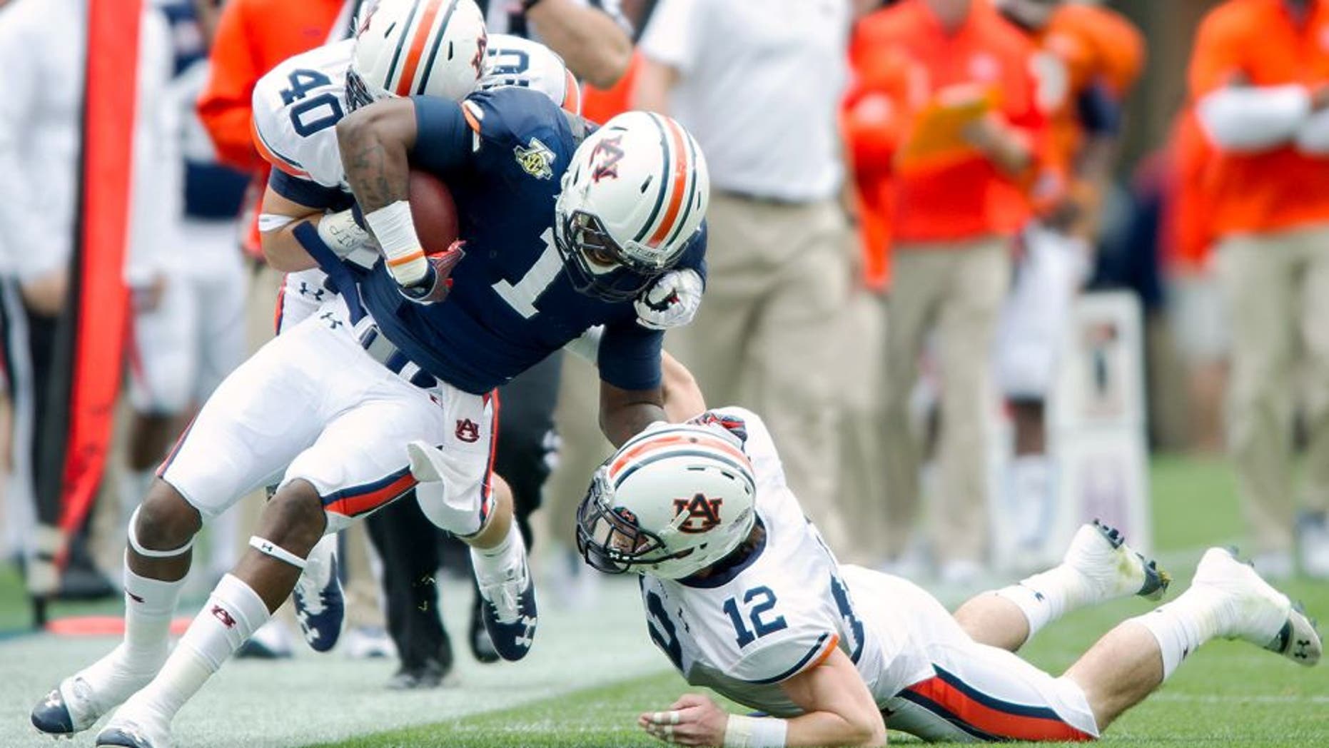AUBURN, AL - APRIL 19: Linebacker Daniel Pond #40 and defensive back Mack VanGorder #12 of the Auburn Tigers attempts to tackle wide receiver D'haquille Williams #1 of the Auburn Tigers during Auburn's A-Day game on April 19, 2014 at Jordan-Hare Stadium in Auburn, Alabama. The blue team defeated the white team 58-3. (Photo by Michael Chang/Getty Images)