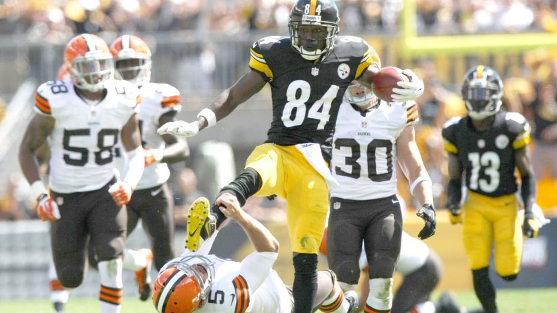 Sep 7, 2014; Pittsburgh, PA, USA; Pittsburgh Steelers wide receiver Antonio Brown (84) runs over Cleveland Browns punter Spencer Lanning (5) during the first half at Heinz Field. Brown was flagged on the play. Mandatory Credit: Jason Bridge-USA TODAY Sports