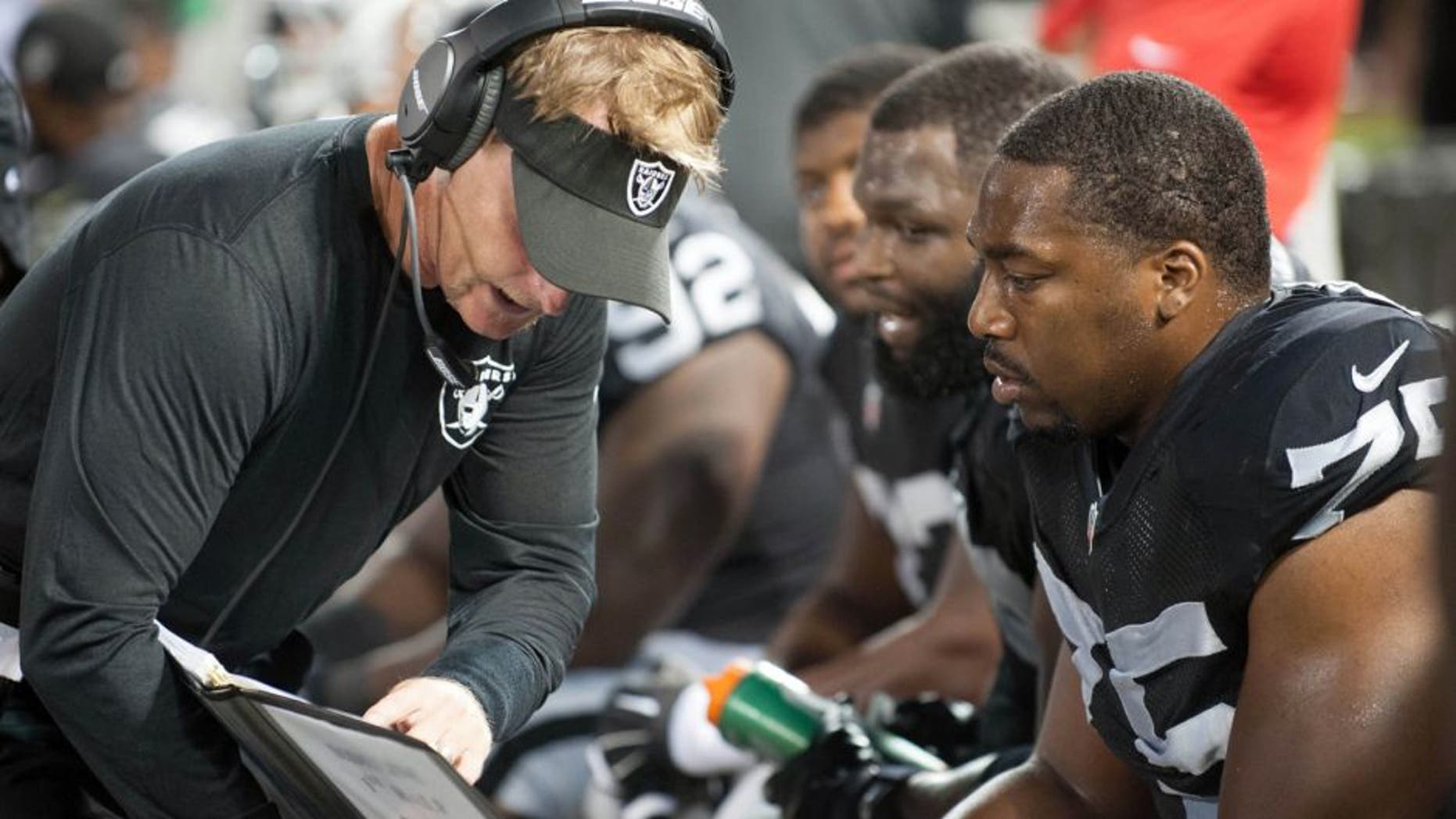 Aug 28, 2014; Oakland, CA, USA; Oakland Raiders defensive coordinator Jason Tarver speaks with defensive end Shelby Harris (75) during the third quarter of the game against the Seattle Seahawks at O.co Coliseum. Mandatory Credit: Ed Szczepanski-USA TODAY Sports