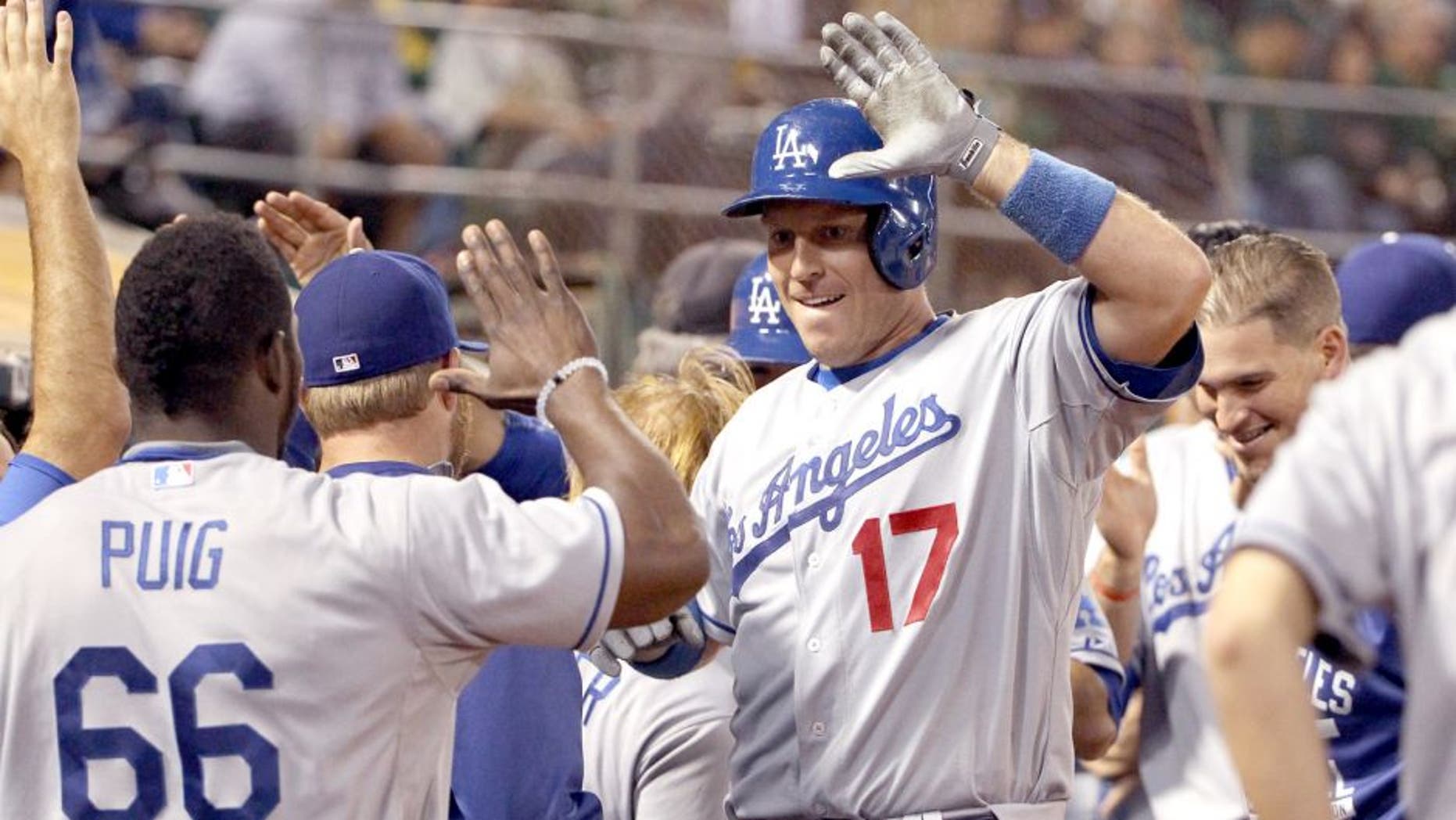 OAKLAND, CA - AUGUST 18: A.J. Ellis #17 of the Los Angeles Dodgers is congratulated by teammates after he hit a three-run home run in the eighth inning of their game against the Oakland Athletics at O.co Coliseum on August 18, 2015 in Oakland, California. (Photo by Ezra Shaw/Getty Images)