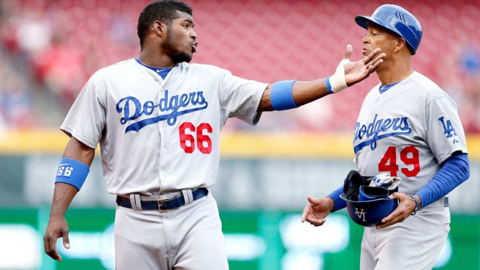 CINCINNATI, OH - JUNE 9: Yasiel Puig #66 of the Los Angeles Dodgers talks to third base coach Lorenzo Bundy during the game against the Cincinnati Reds at Great American Ball Park on June 9, 2014 in Cincinnati, Ohio. The Dodgers won 6-2. (Photo by Joe Robbins/Getty Images) *** Local Caption *** Yasiel Puig;Lorenzo Bundy
