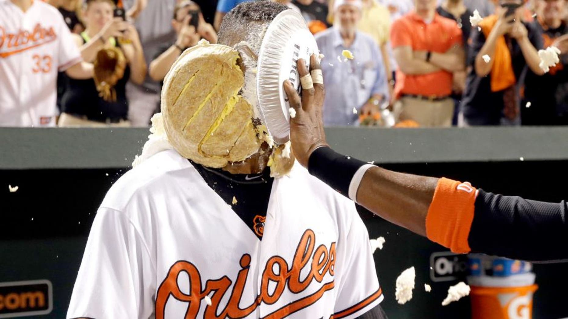 Baltimore Orioles' Henry Urrutia is hit in the face with a pie by teammate Adam Jones after a baseball game against the New York Mets, Wednesday, Aug. 19, 2015, in Baltimore. Urrutia hit a solo home run in the ninth to give Baltimore a 5-4 win. (AP Photo/Patrick Semansky)
