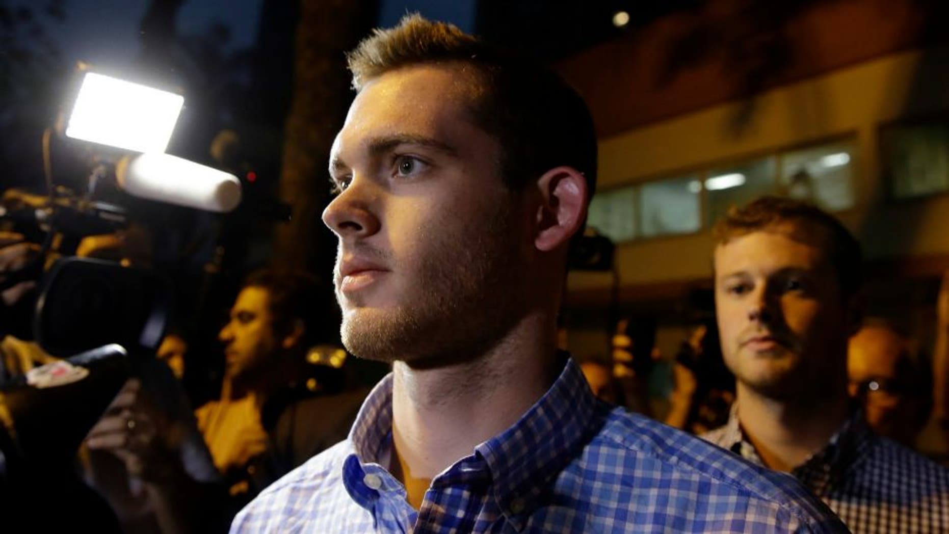 American Olympic swimmers Gunnar Bentz, front, and Jack Conger leave a police station in the Leblon neighborhood of Rio de Janeiro, Brazil, Thursday, Aug. 18, 2016. The two were taken off their flight from Brazil to the U.S. on Wednesday by local authorities amid an investigation into a reported robbery targeting Ryan Lochte and his teammates. A Brazilian police officer told The Associated Press that Lochte fabricated a story about being robbed at gunpoint in Rio de Janeiro. (AP Photo/Leo Correa)