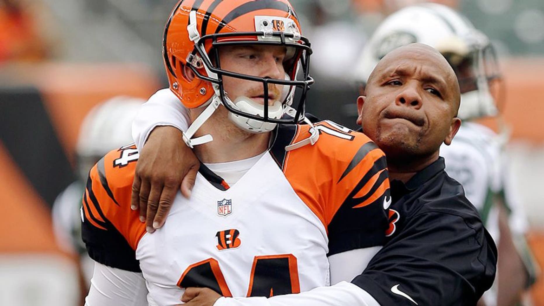 Cincinnati Bengals offensive coordinator Hue Jackson hugs quarterback Andy Dalton (14) prior to an NFL preseason football game against the New York Jets, Saturday, Aug. 16, 2014, in Cincinnati. (AP Photo/Al Behrman)