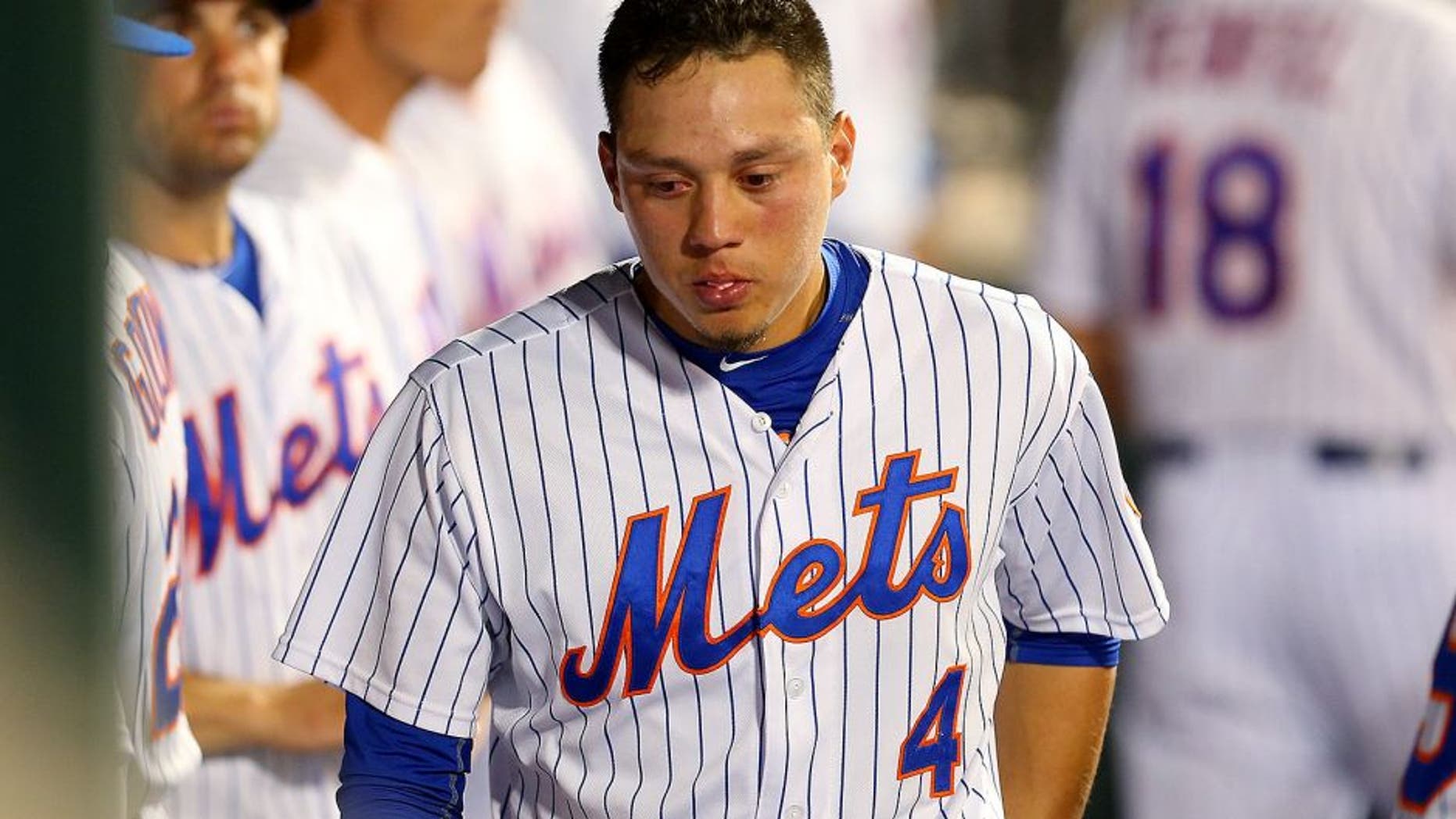 NEW YORK, NY - JULY 29: Wilmer Flores #4 of the New York Mets looks on in the dugout in the ninth inning duirng the game against the San Diego Padres at Citi Field on July 29, 2015 in Flushing neighborhood of the Queens borough of New York City. (Photo by Mike Stobe/Getty Images)