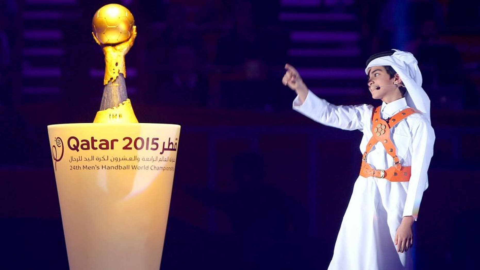 A young boy points to the trophy during the podium ceremony of 24th Men's Handball World Championships at the Lusail Multipurpose Hall in Doha on February 1, 2015. France became the first team in handball history to win five world championships when they beat surprise finalists Qatar 25-22. AFP PHOTO / MARWAN NAAMANI (Photo credit should read MARWAN NAAMANI/AFP/Getty Images)