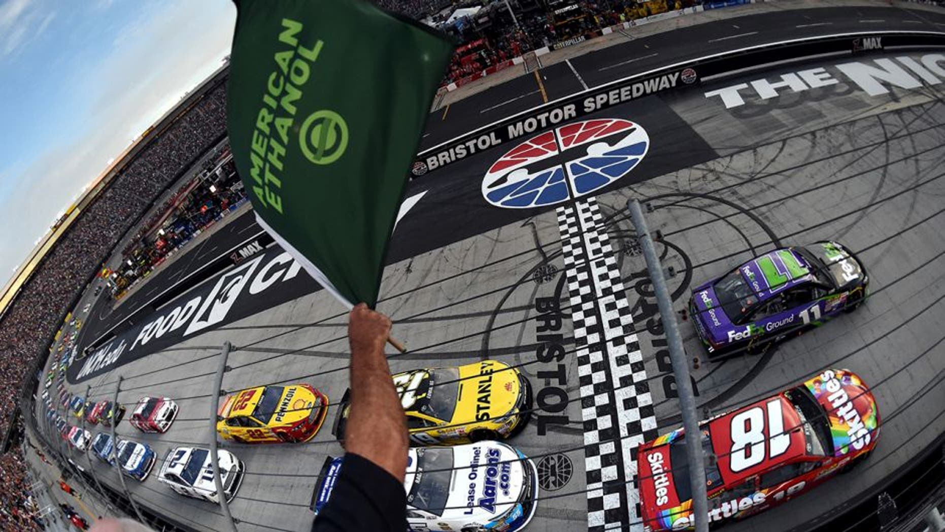 BRISTOL, TN - AUGUST 22: Denny Hamlin, driver of the #11 FedEx Ground Toyota, and Kyle Busch, driver of the #18 Skittles Toyota, lead the field through the green flag to start the NASCAR Sprint Cup Series IRWIN Tools Night Race at Bristol Motor Speedway on August 22, 2015 in Bristol, Tennessee. (Photo by Rainier Ehrhardt/NASCAR via Getty Images)