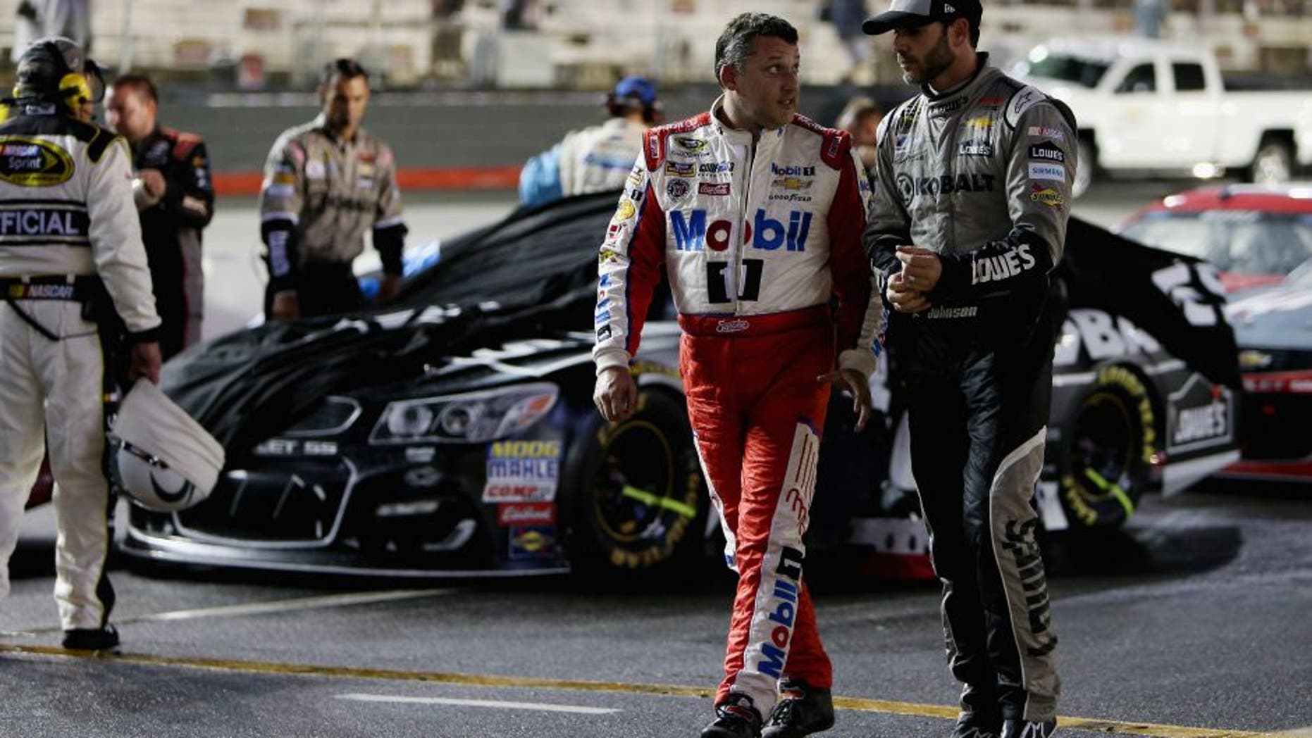 BRISTOL, TN - AUGUST 20: Tony Stewart, driver of the #14 Haas Automation Chevrolet, walks on the grid with Jimmie Johnson, driver of the #48 Kobalt Chevrolet, during a rain delay during the NASCAR Sprint Cup Series Bass Pro Shops NRA Night Race at Bristol Motor Speedway on August 20, 2016 in Bristol, Tennessee. (Photo by Rey Del Rio/Getty Images)