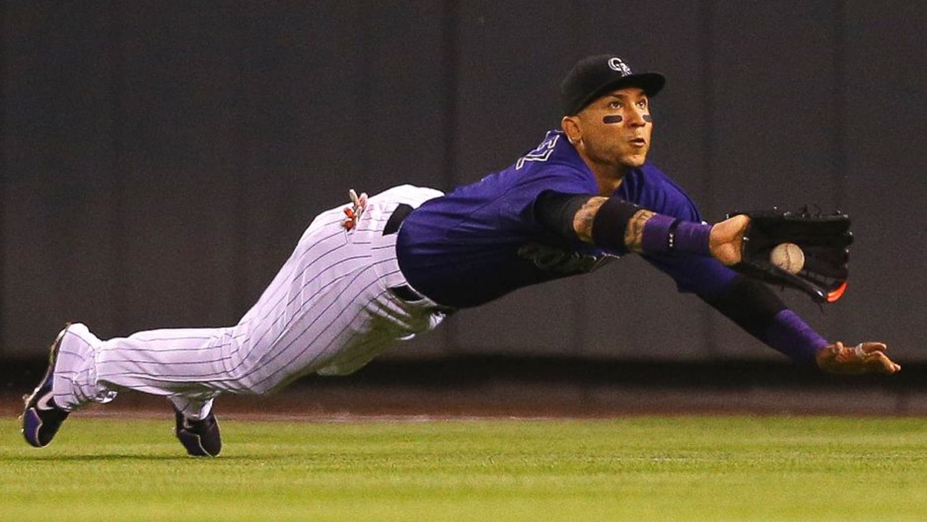 DENVER, CO - AUGUST 20: Right fielder Carlos Gonzalez #5 of the Colorado Rockies makes a diving catch to rob Jayson Werth of the Washington Nationals of a single in the eighth inning at Coors Field on August 20, 2015 in Denver, Colorado. (Photo by Justin Edmonds/Getty Images)