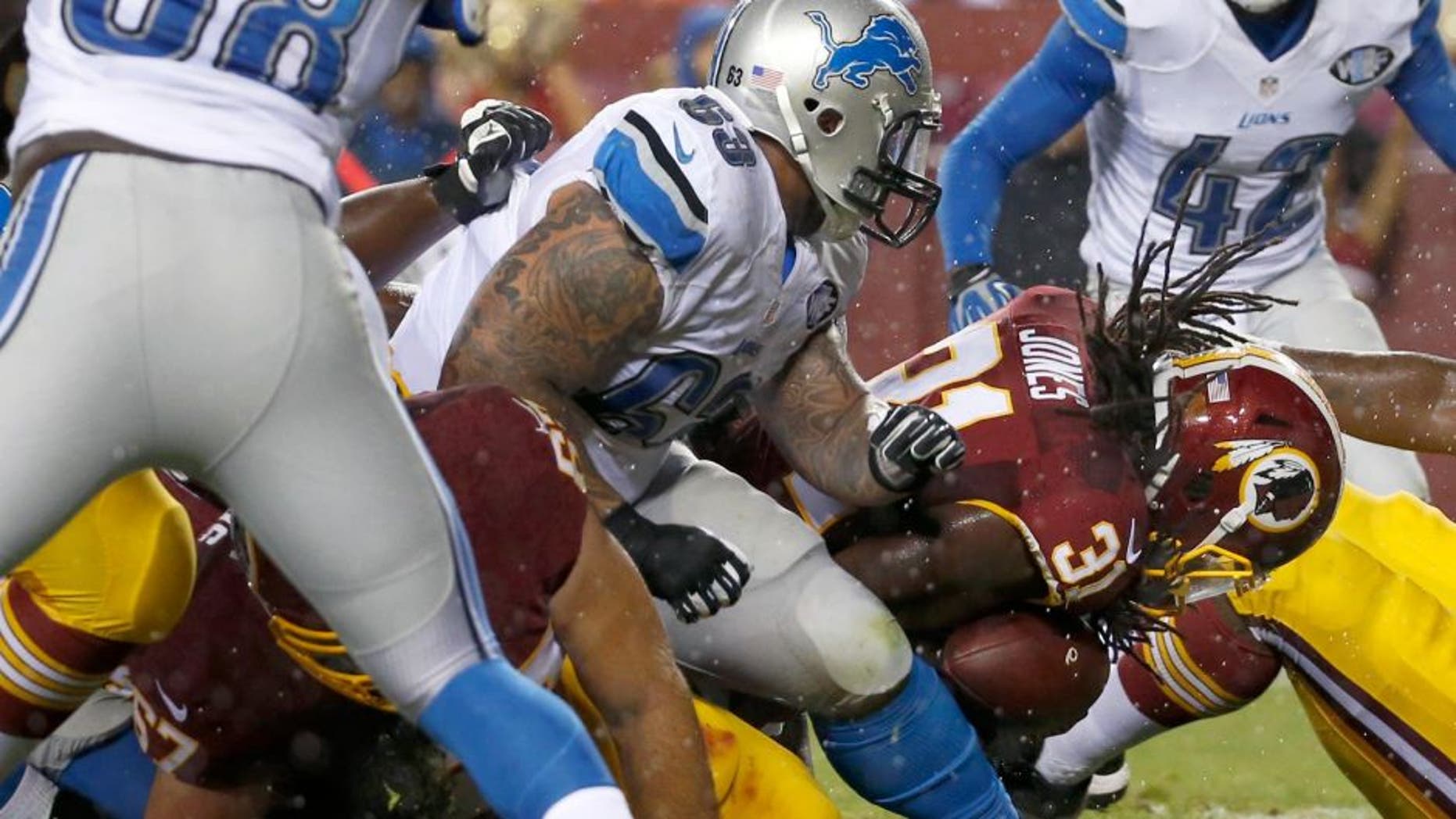 Washington Redskins running back Matt Jones (31) dives past Detroit Lions defensive tackle Jermelle Cudjo (63) to score a touchdown during the first half of an NFL preseason football game, Thursday, Aug. 20, 2015, in Landover, Md. (AP Photo/Alex Brandon)