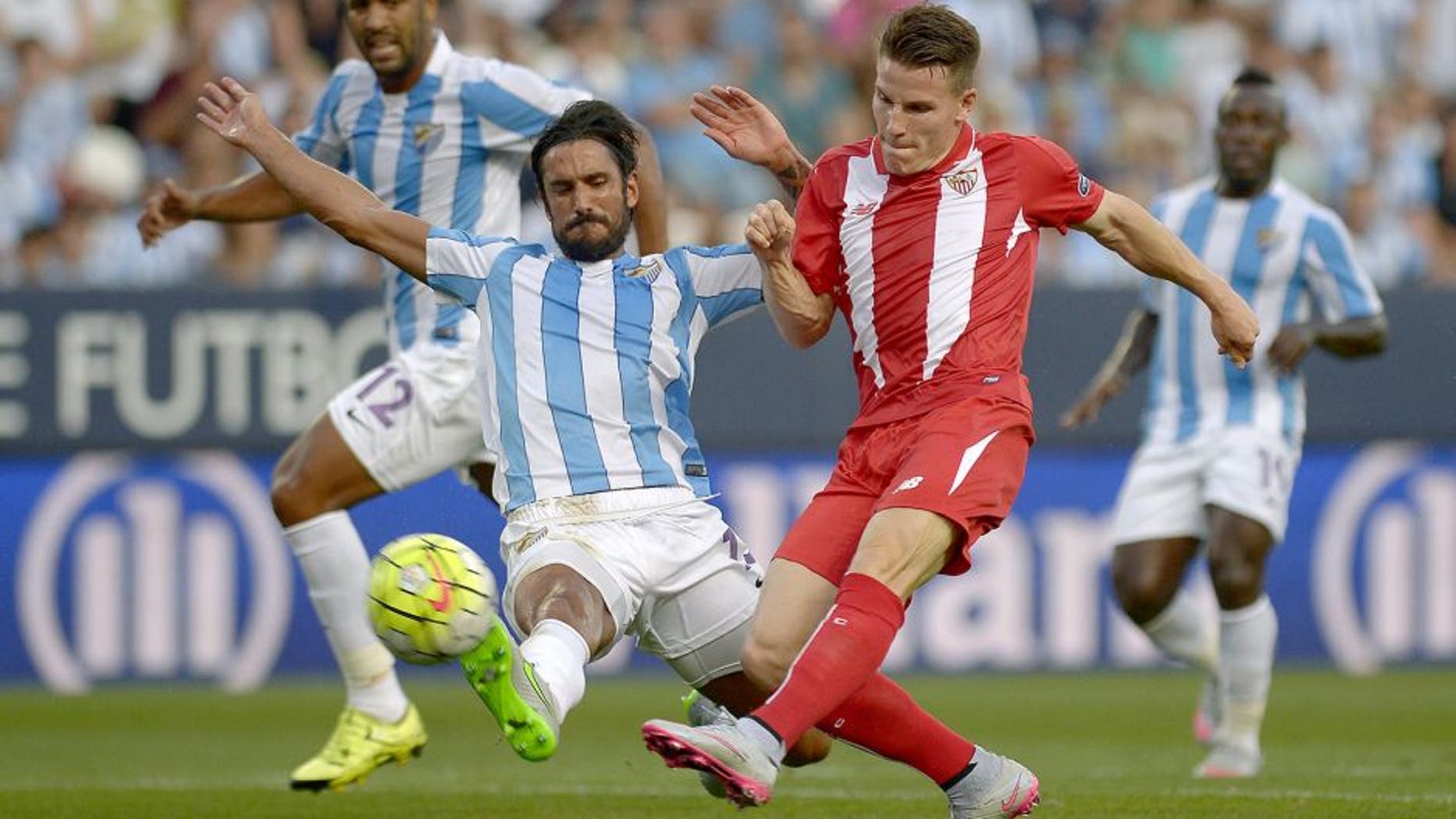 Malaga's Argentinian defender Marcos Alberto Angeleri (L) vies with Sevilla's French forward Kevin Gameiro during the Spanish league football match Malaga CF vs Sevilla FC at La Rosaleda stadium in Malaga on August 21, 2015. AFP PHOTO / JORGE GUERRERO (Photo credit should read Jorge Guerrero/AFP/Getty Images)