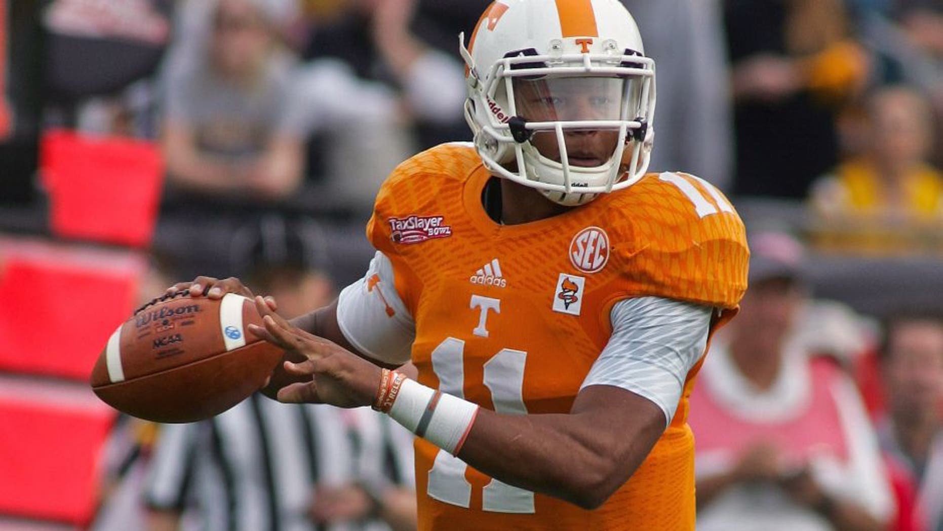 Jan 2, 2015; Jacksonville, FL, USA; Tennessee Volunteers quarterback Joshua Dobbs (11) looks for a receiver in the first quarter of the 2015 TaxSlayer Bowl against the Iowa Hawkeyes at EverBank Field. The Tennessee Volunteers beat the Iowa Hawkeyes 45-28. Mandatory Credit: Phil Sears-USA TODAY Sports