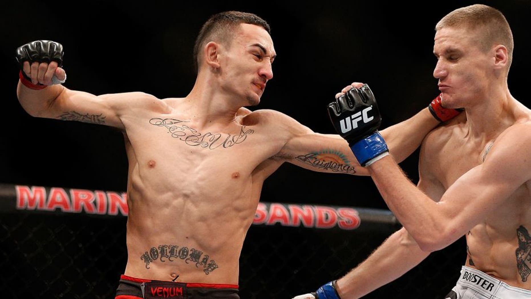 SINGAPORE - JANUARY 04: (L-R) Max Holloway punches Will Chope in their featherweight bout during the UFC Fight Night event at the Marina Bay Sands Resort on January 4, 2014 in Singapore. (Photo by Josh Hedges/Zuffa LLC/Zuffa LLC via Getty Images)