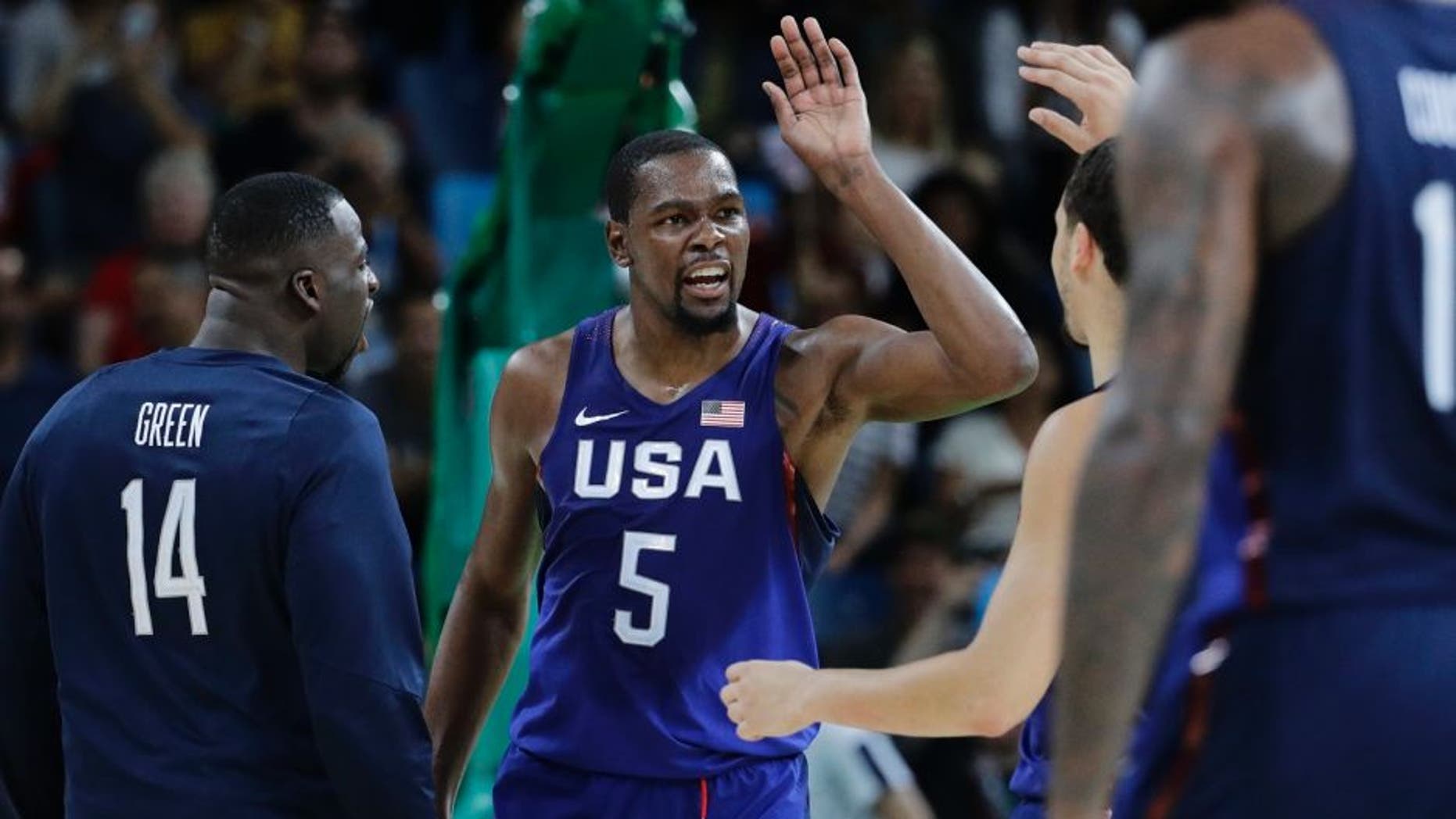 United States' Kevin Durant (5) celebrates with teammates United States' Draymond Green (14) and others after a steal and dunk against Serbia during the men's gold medal basketball game at the 2016 Summer Olympics in Rio de Janeiro, Brazil, Sunday, Aug. 21, 2016. (AP Photo/Matt York)