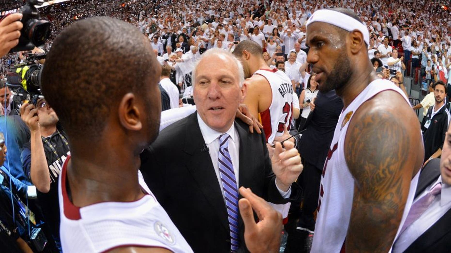 MIAMI, FL - JUNE 20: Gregg Popovich of the San Antonio Spurs congratulates Dwyane Wade #3 and LeBron James #6 of the Miami Heat in Game Seven of the 2013 NBA Finals on June 20, 2013 at American Airlines Arena in Miami, Florida. NOTE TO USER: User expressly acknowledges and agrees that, by downloading and or using this photograph, User is consenting to the terms and conditions of the Getty Images License Agreement. Mandatory Copyright Notice: Copyright 2013 NBAE (Photo by Jesse D. Garrabrant/NBAE via Getty Images)