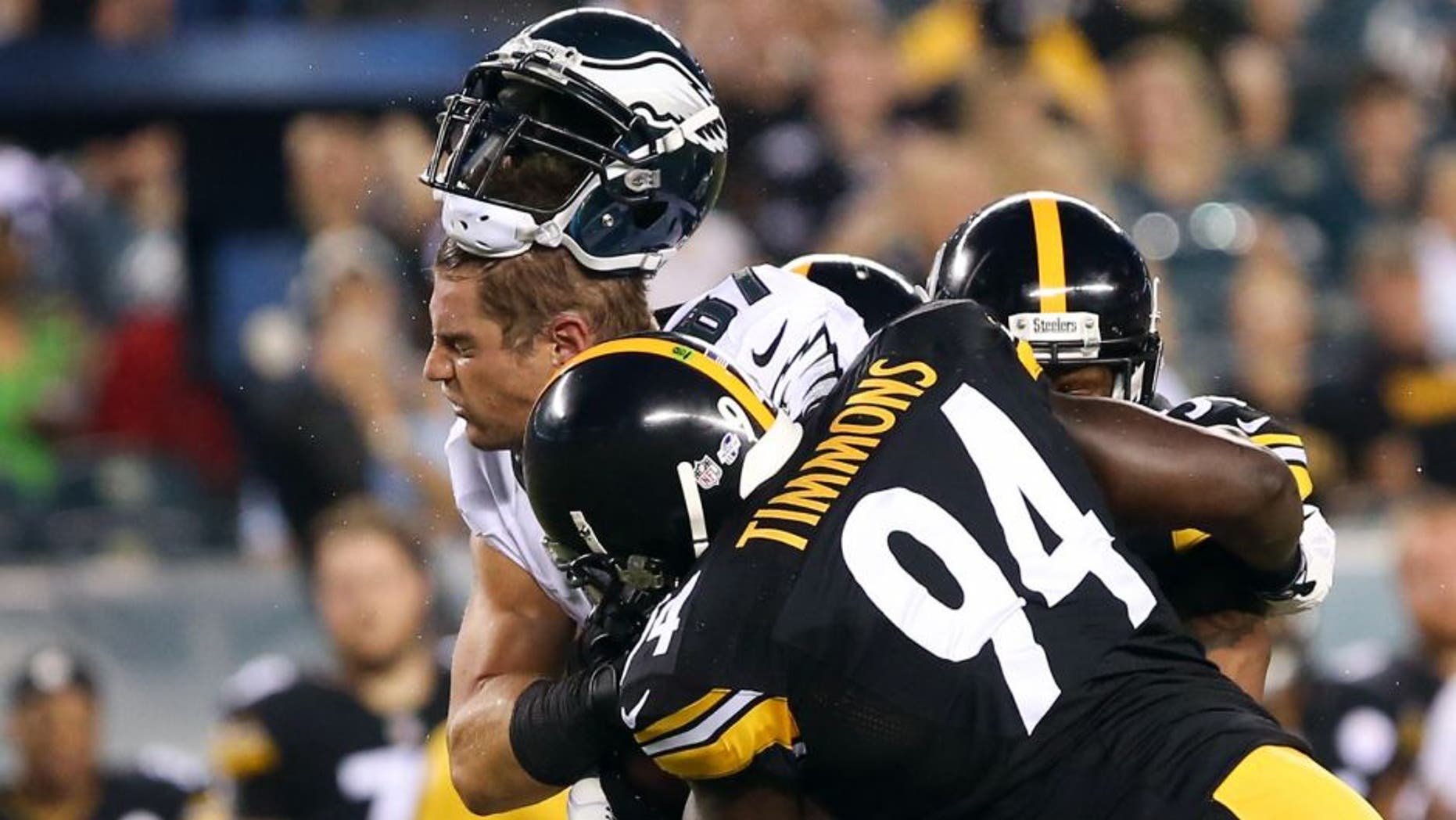 Aug 21, 2014; Philadelphia, PA, USA; Philadelphia Eagles tight end Brent Celek (87) makes a catch and has his helmet knocked off by Pittsburgh Steelers inside linebacker Lawrence Timmons (94) during the first quarter of a game at Lincoln Financial Field. Mandatory Credit: Bill Streicher-USA TODAY Sports
