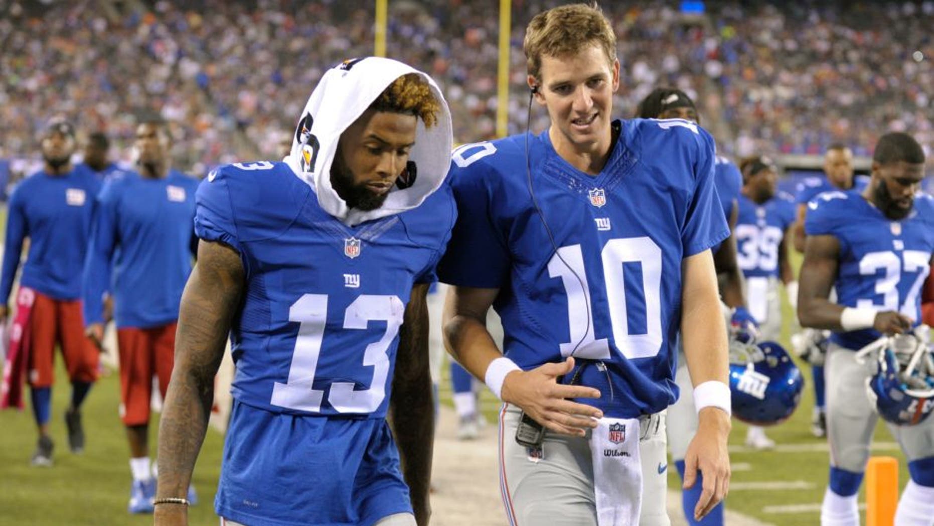 New York Giants quarterback Eli Manning (10) and Odell Beckham (13) talk while walking off the field after the first half of a preseason NFL football game against the Jacksonville Jaguars, Saturday, Aug. 22, 2015, in East Rutherford, N.J. (AP Photo/Bill Kostroun)