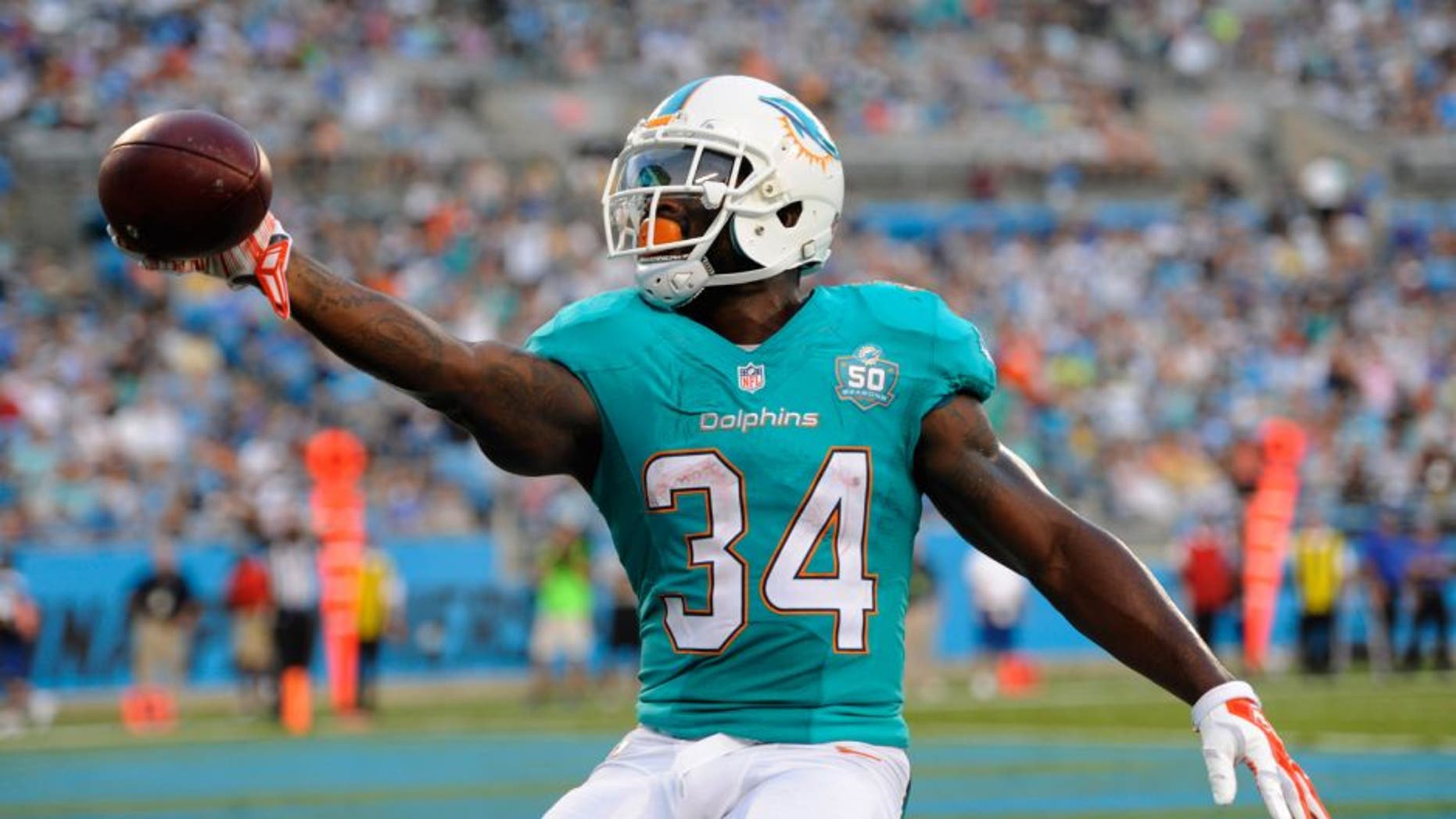 Aug 22, 2015; Charlotte, NC, USA; Miami Dolphins running back Damien Williams (34) scores a touchdown during the first half of the game against the Carolina Panthers at Bank of America Stadium. Mandatory Credit: Sam Sharpe-USA TODAY Sports