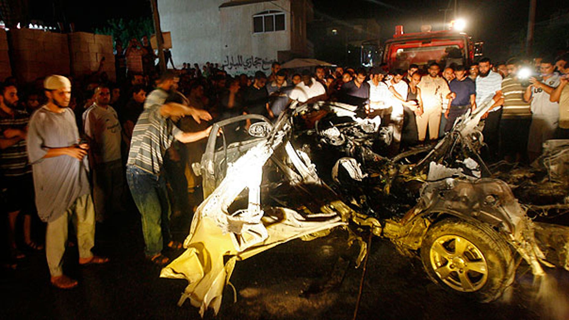 Aug. 24: Palestinians look at the wreckage of a car after it was hit by an Israeli missile, killing an Islamic Jihad militant in Rafah, southern Gaza Strip.