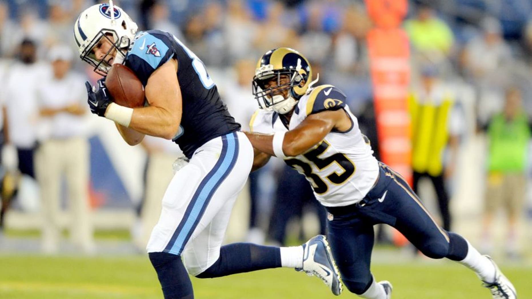 Aug 23, 2015; Nashville, TN, USA; Tennessee Titans tight end Chase Coffman (85) catches a touchdown pass while being defended by St. Louis Rams safety Jay Hughes (35) during the second half at Nissan Stadium. The Titans won 27-14. Mandatory Credit: Christopher Hanewinckel-USA TODAY Sports
