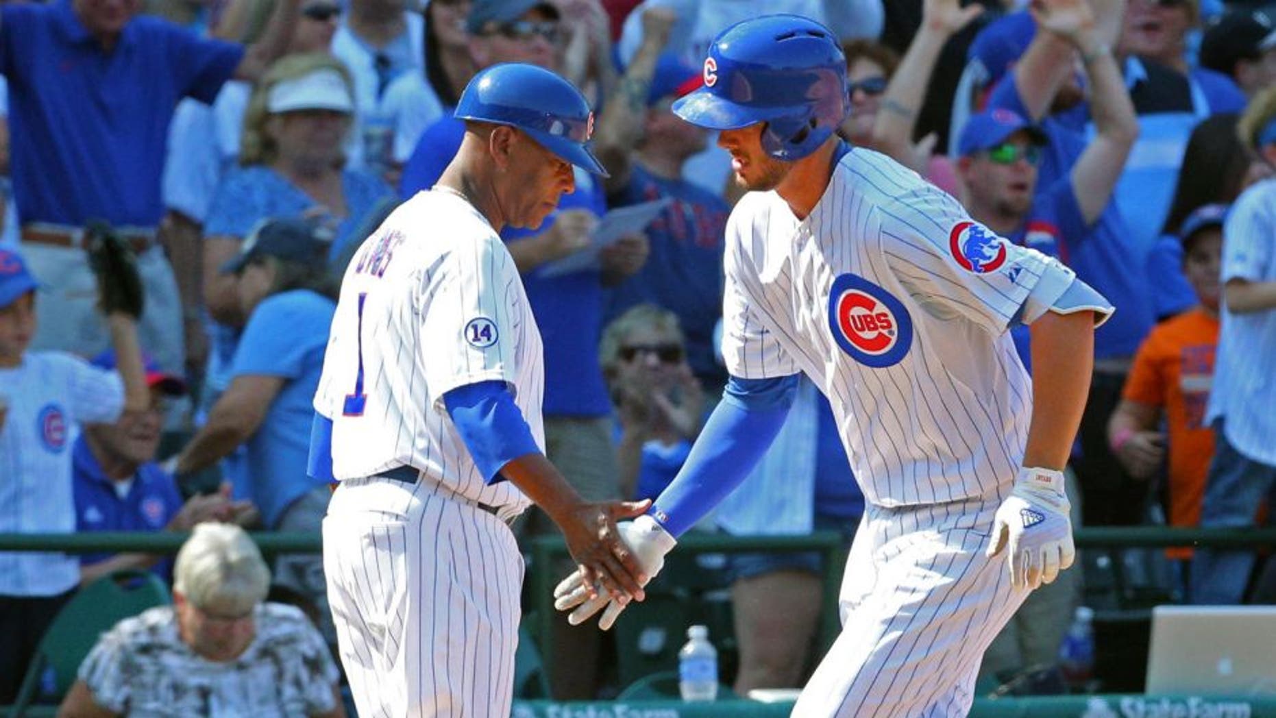 Aug 23, 2015; Chicago, IL, USA; Chicago Cubs third baseman Kris Bryant (17) is congratulated for hitting a home run by third base coach Gary Jones (1) during the sixth inning against the Atlanta Braves at Wrigley Field. Mandatory Credit: Dennis Wierzbicki-USA TODAY Sports