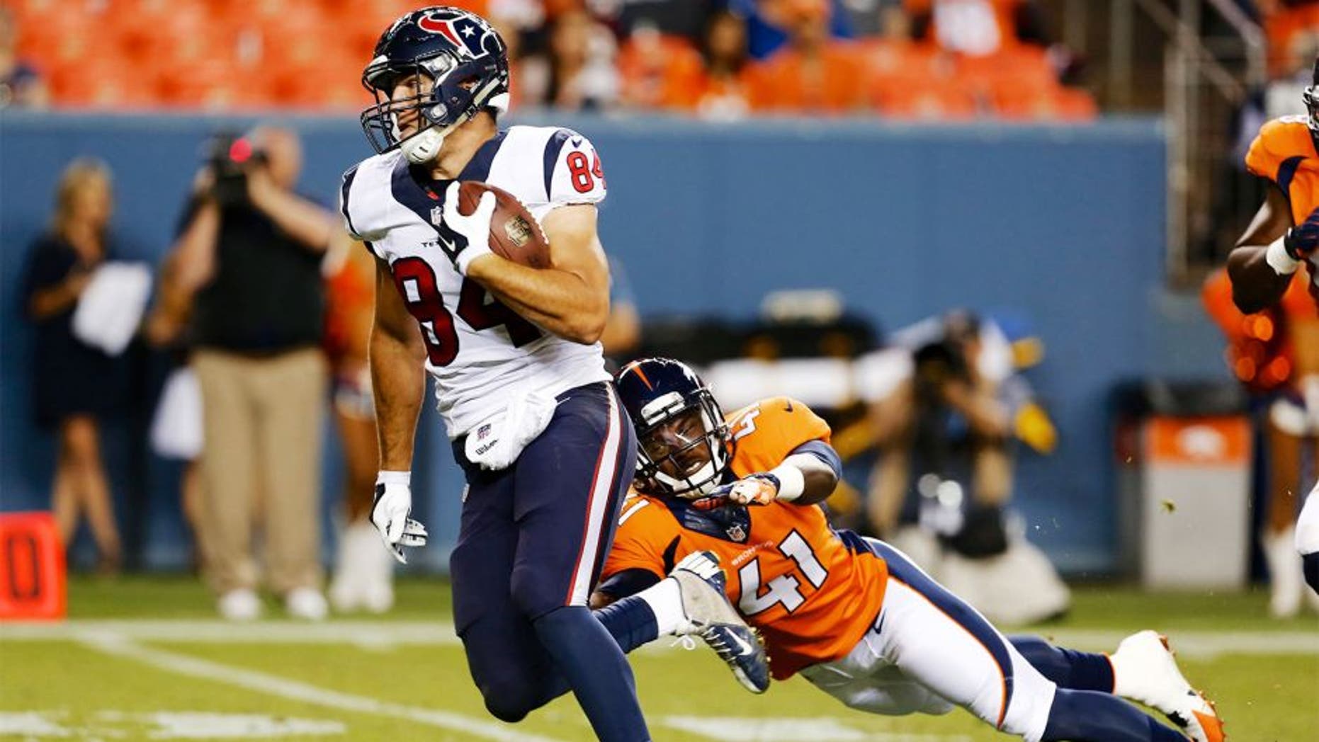 Aug 23, 2014; Denver, CO, USA; Houston Texans tight end Ryan Griffin (84) avoids the tackle of Denver Broncos defensive back Charles Mitchell (41) to run for a touchdown in the fourth quarter at Sports Authority Field at Mile High. The Texans defeated the Broncos 18-17. Mandatory Credit: Isaiah J. Downing-USA TODAY Sports