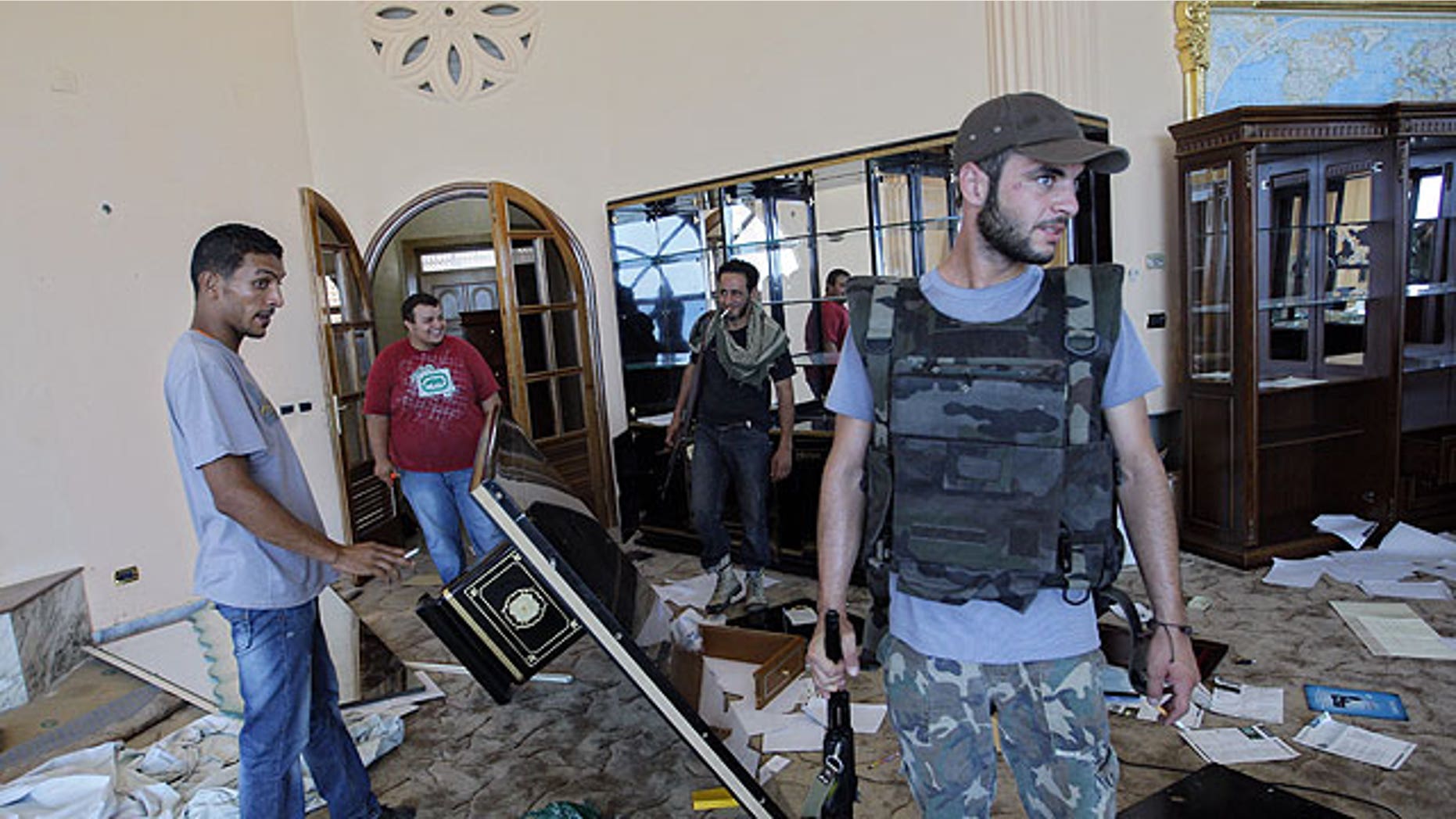 August 24: A rebel fighter walks inside the house of Al-Saadi Qaddafi, the son of Libyan dictator Muammar Qaddafi in Tripoli, Libya,