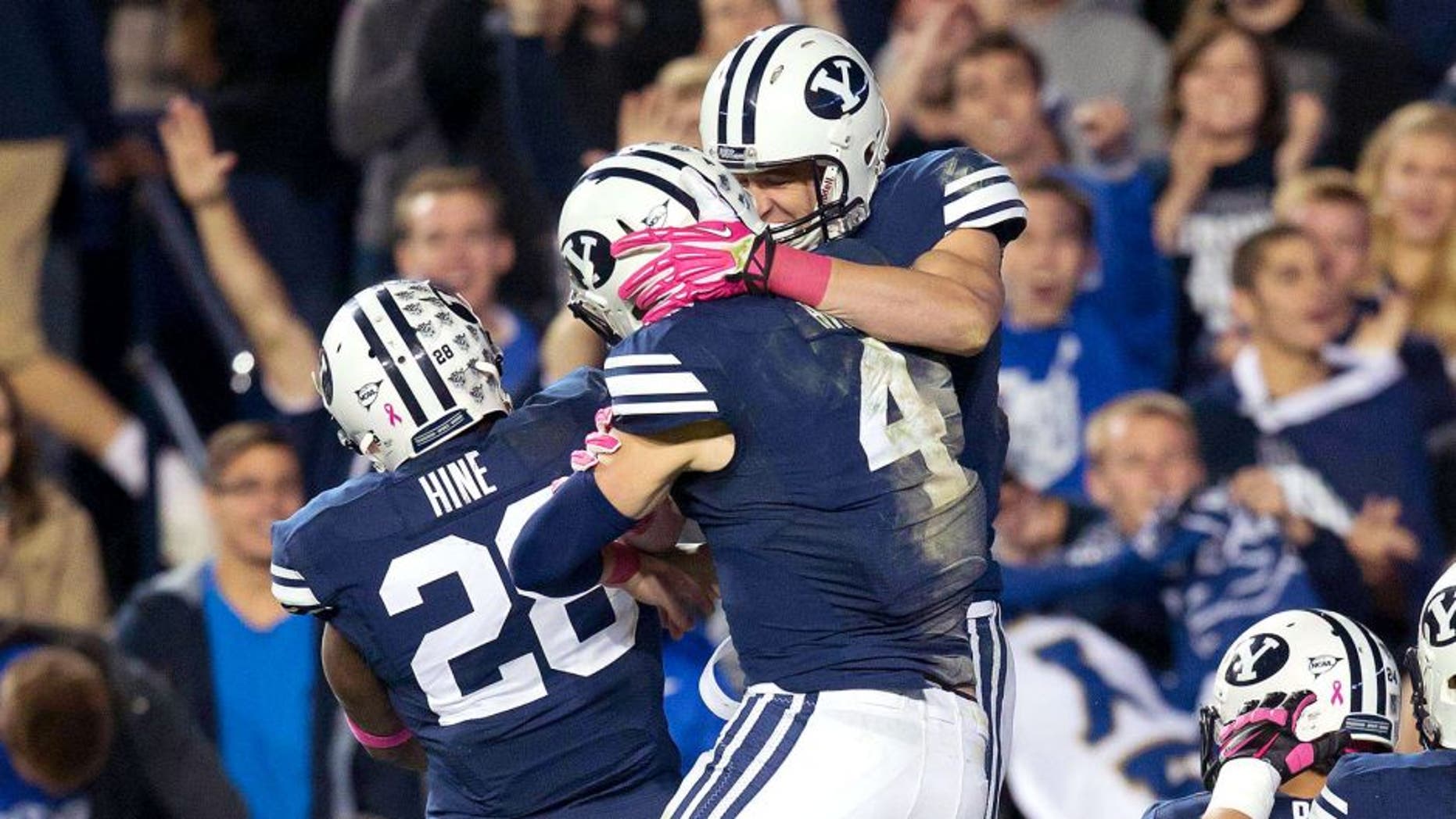Oct 25, 2013; Provo, UT, USA; Brigham Young Cougars running back Adam Hine (28) and quarterback Taysom Hill (4) celebrate a touchdown by wide receiver Mitch Mathews (10) during the second half at Lavell Edwards Stadium. Brigham Young won 37-20. Mandatory Credit: Russ Isabella-USA TODAY Sports