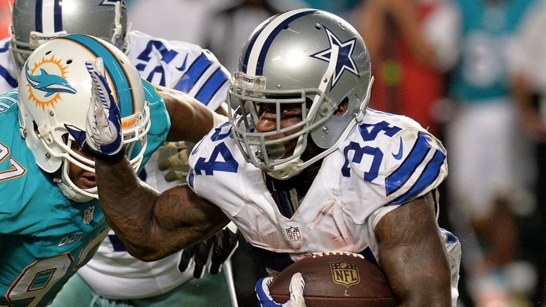 Aug 23, 2014; Miami Gardens, FL, USA; Dallas Cowboys running back Ryan Williams (34) is tackled by Miami Dolphins nose tackle Isaako Aaitui (97) during the second half at Sun Life Stadium. The Dolphins won 25-20. Mandatory Credit: Steve Mitchell-USA TODAY Sports