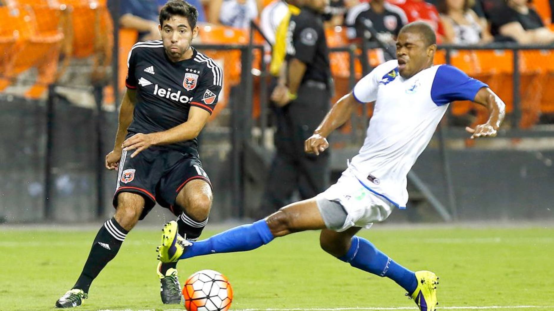 Aug 25, 2015; Washington, DC, USA; D.C. United midfielder Miguel Aguilar (17) passes the ball as Montego Bay F.C. defender Dwayne Holmes (5) defends in the first half at RFK Stadium. United won 3-0. Mandatory Credit: Geoff Burke-USA TODAY Sports