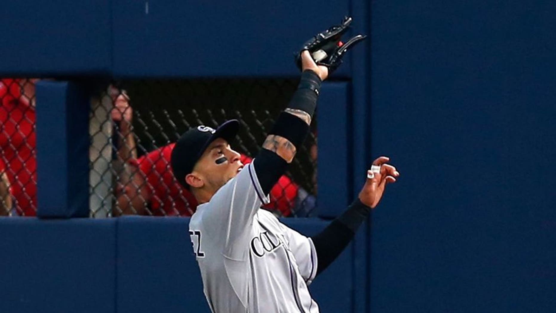 ATLANTA, GA - AUGUST 24: Right fielder Carlos Gonzalez #5 of the Colorado Rockies makes a sliding catch in the third inning during the game against the Atlanta Braves at Turner Field on August 24, 2015 in Atlanta, Georgia. (Photo by Mike Zarrilli/Getty Images)