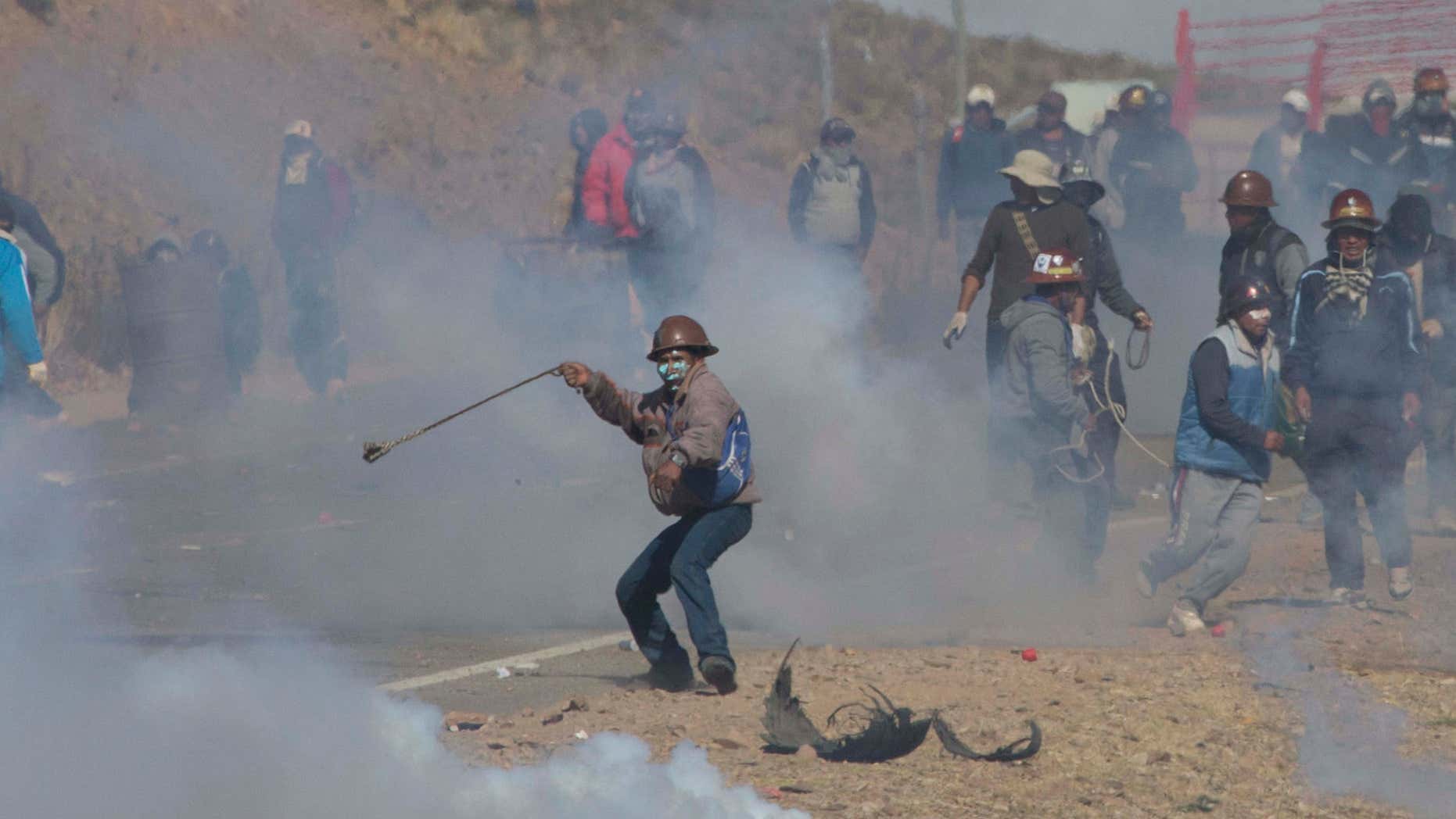 Aug. 25, 2016: Independent miners clash with the police as they run from clouds of tear gas during protests in Panduro, Bolivia.