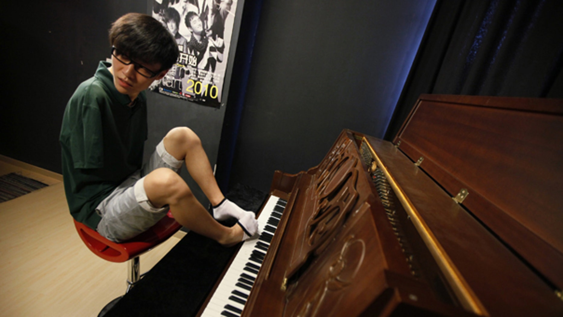 Aug. 26: Pianist Liu Wei takes off one of his socks to play piano in Shanghai. The 23-year-old's arms were amputated after a childhood accident.