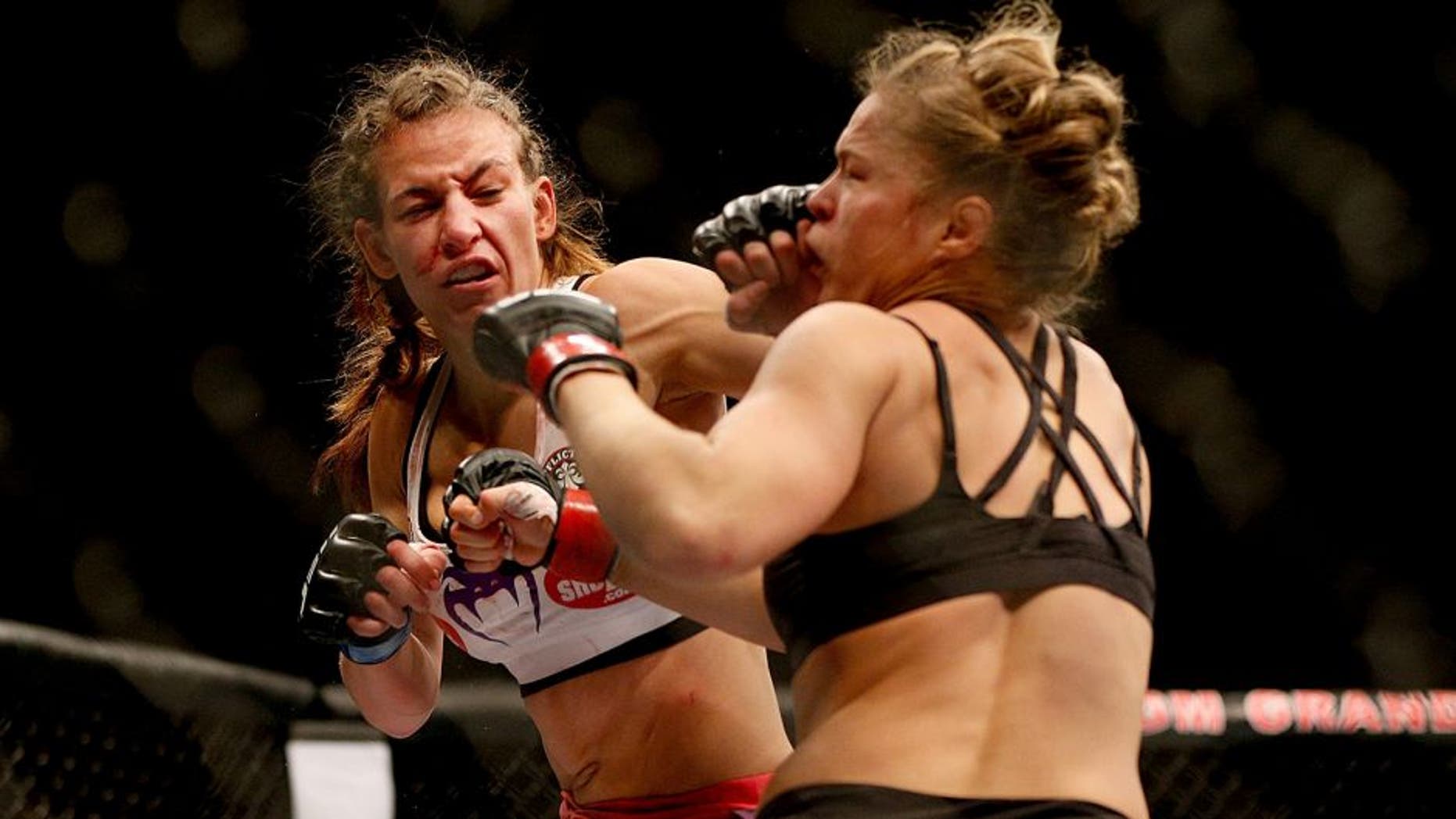 LAS VEGAS, NV - DECEMBER 28: (L-R) Miesha Tate punches Ronda Rousey in their UFC women's bantamweight championship bout during the UFC 168 event at the MGM Grand Garden Arena on December 28, 2013 in Las Vegas, Nevada. (Photo by Josh Hedges/Zuffa LLC/Zuffa LLC via Getty Images)
