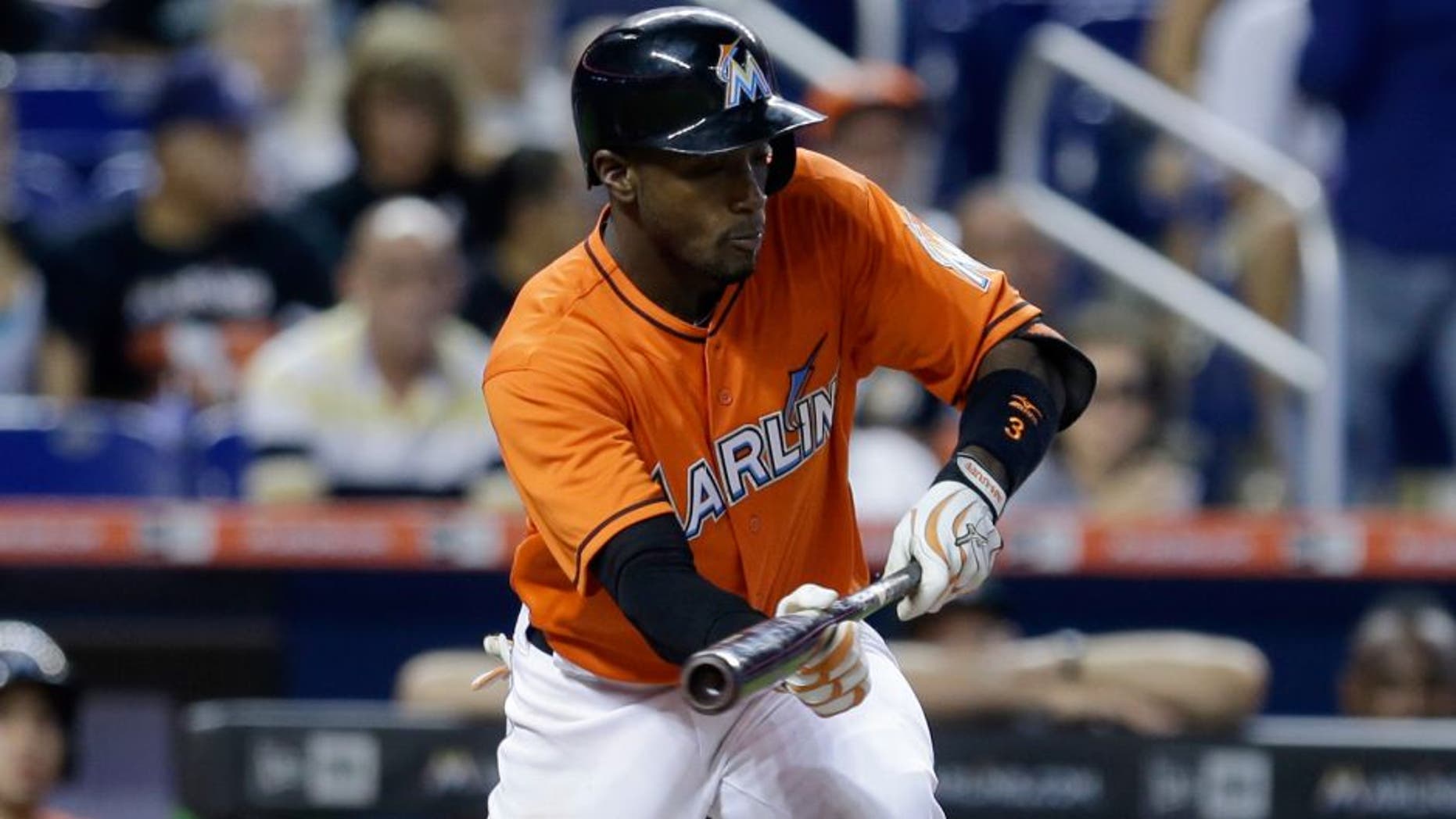 Miami Marlins' Adeiny Hechavarria (3) bunts against the Philadelphia Phillies in the fifth inning of a baseball game, Sunday, Aug. 23, 2015, in Miami. Hechavarria was safe at first base. (AP Photo/Alan Diaz)