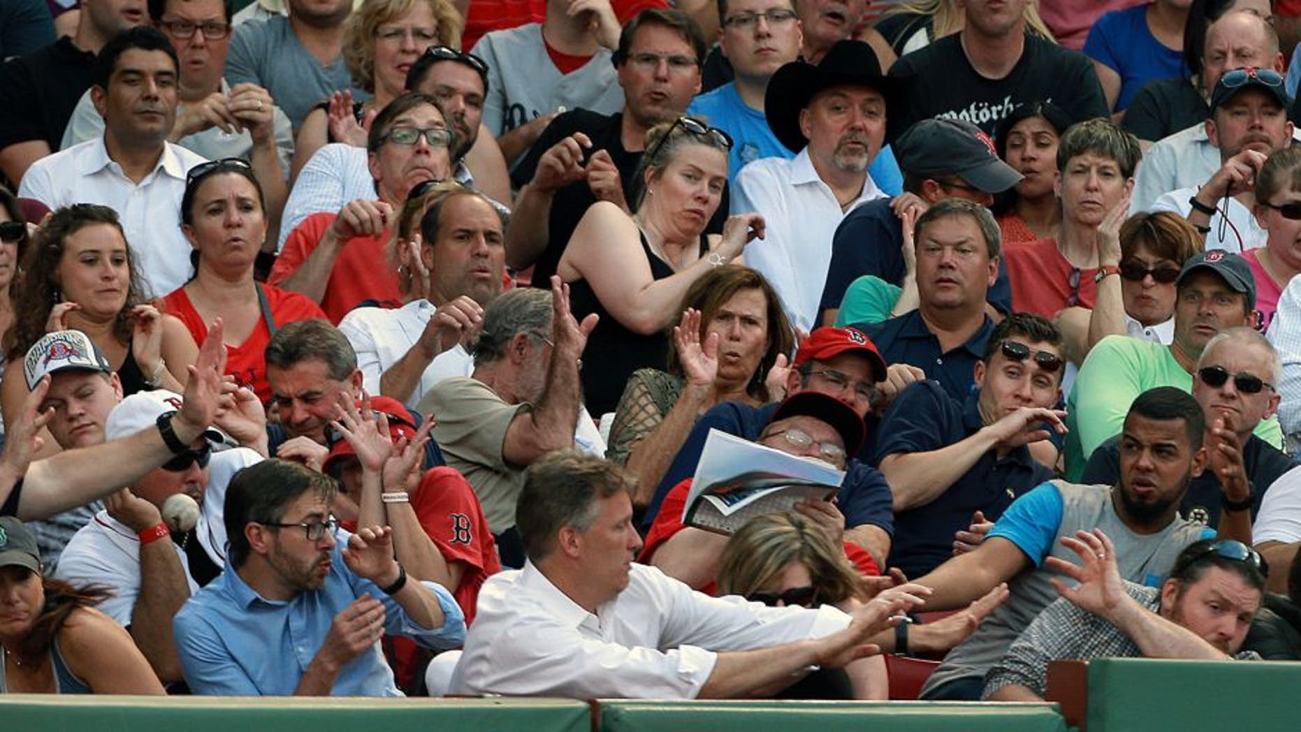 BOSTON - JUNE 17: Fans along the third base line duck for cover as a foul ball screams at them. The Boston Red Sox hosted the Minnesota Twins in a regular season MLB game at Fenway Park. (Photo by Jim Davis/The Boston Globe via Getty Images)