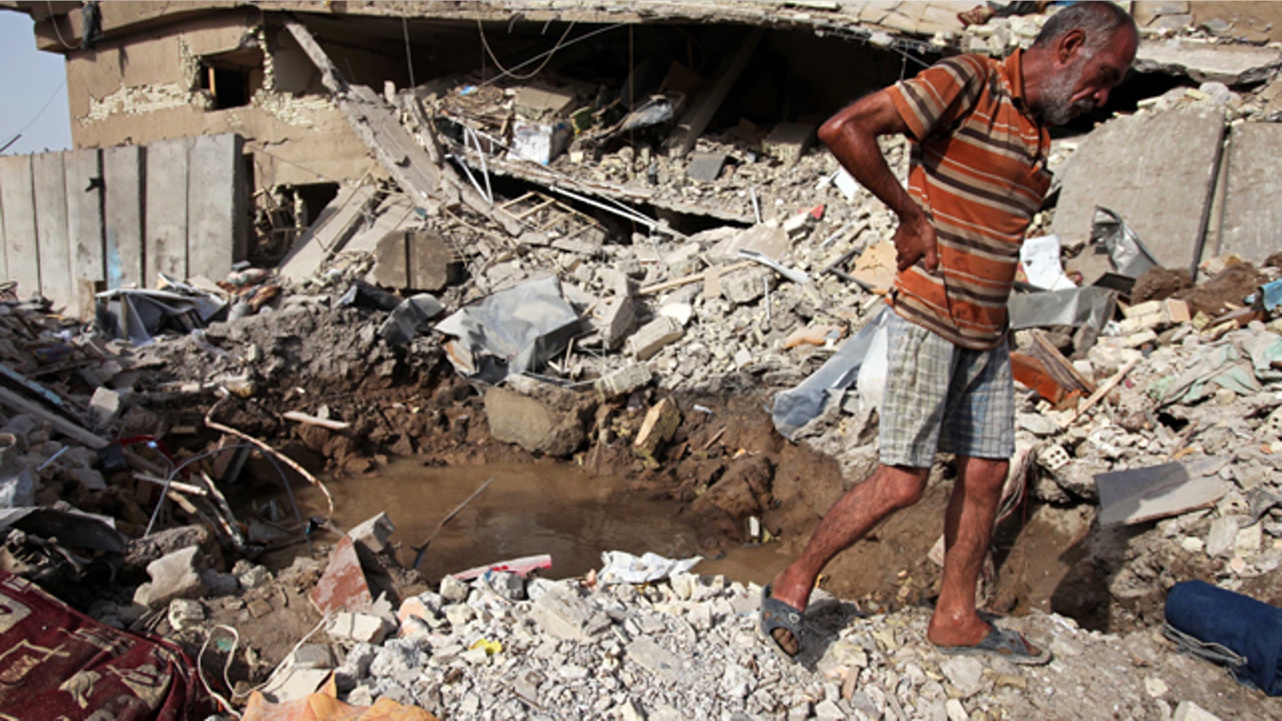 Aug. 26: An Iraqi man surveys the ruins of a collapsed building the day after a bombing in Baghdad, Iraq.