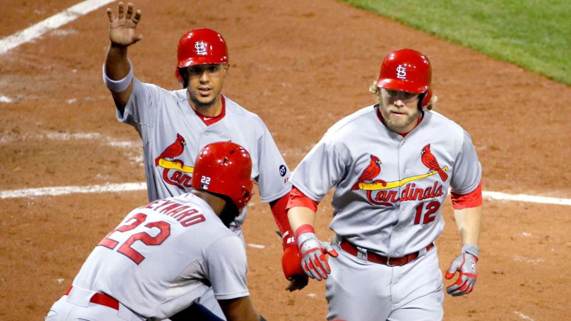 St. Louis Cardinals' Mark Reynolds (12) celebrates with teammates Jon Jay, left rear, and Jason Heyward (22) after hitting a pinch hit two-run home run off Pittsburgh Pirates relief pitcher Mark Melancon in the ninth inning of a baseball game in Pittsburgh, Monday, Sept. 28, 2015. (AP Photo/Gene J. Puskar)
